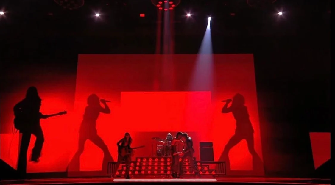 Stage washed in red light, with black silhouettes of the band projected on the backdrops – Måneskin at Eurovision 2021, Rotterdam, Netherlands – concert stage design