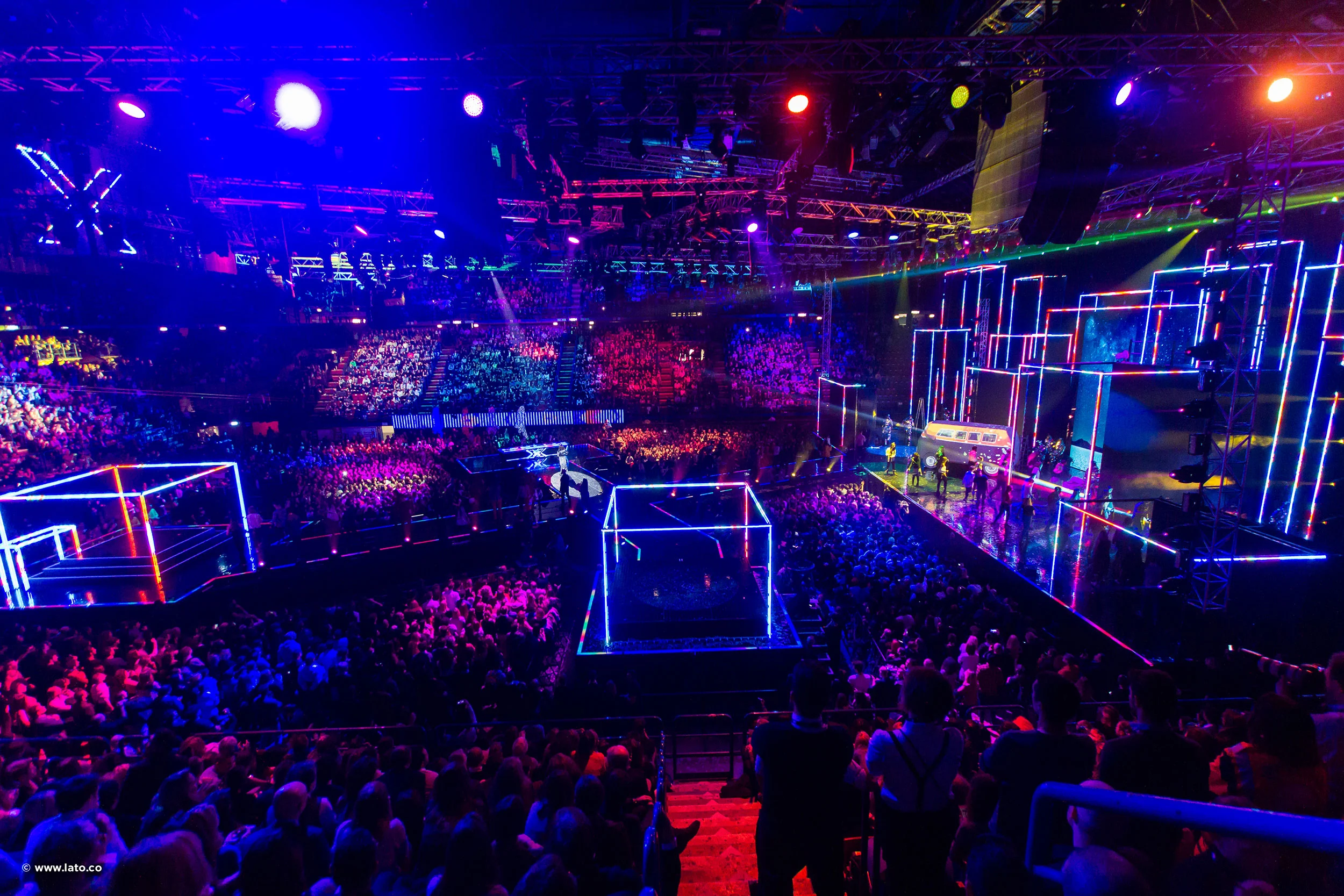 Wide view of the X Factor final at Milan's Forum, with neon-outlined cube stages and a packed arena – X Factor 2016 Final, Milan, Italy – TV stage design