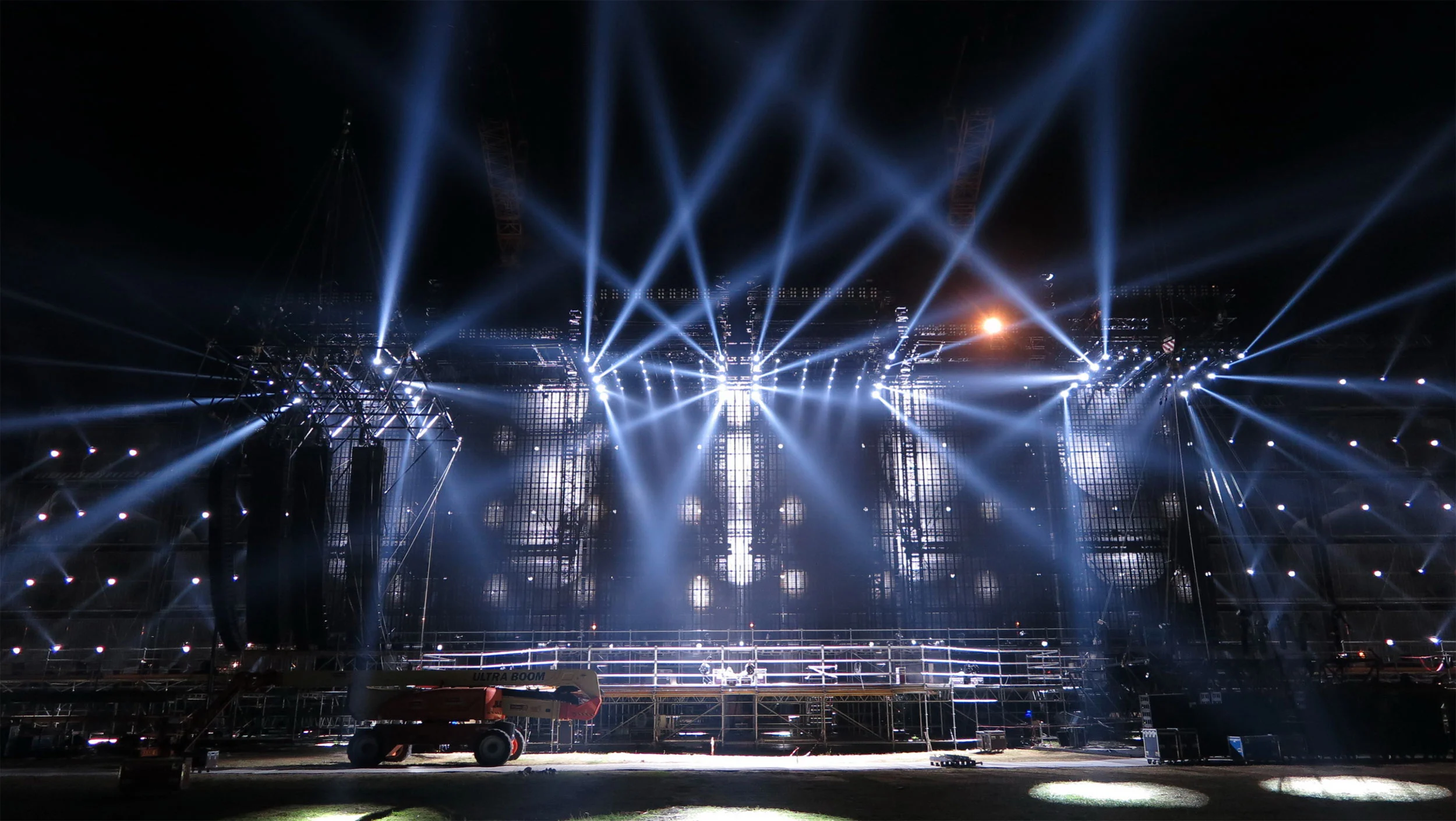 Empty Modena Park stage at night during rehearsal, white light beams fanning out from the truss towers – Vasco Rossi Modena Park, Italy, 2017 – concert stage design