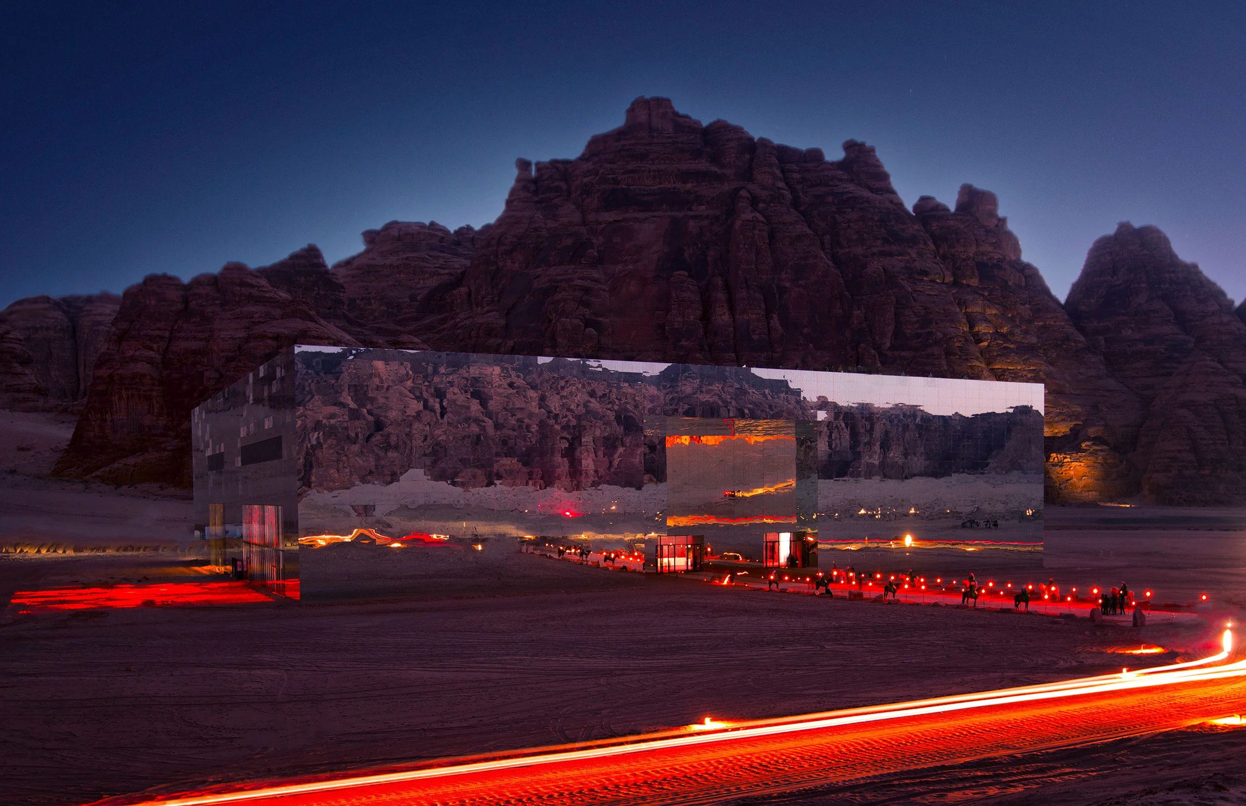 Maraya at night: mirrored building reflecting the cliffs, with red light trails along the desert road – Maraya Concert Hall, AlUla, Saudi Arabia, 2019 – architecture