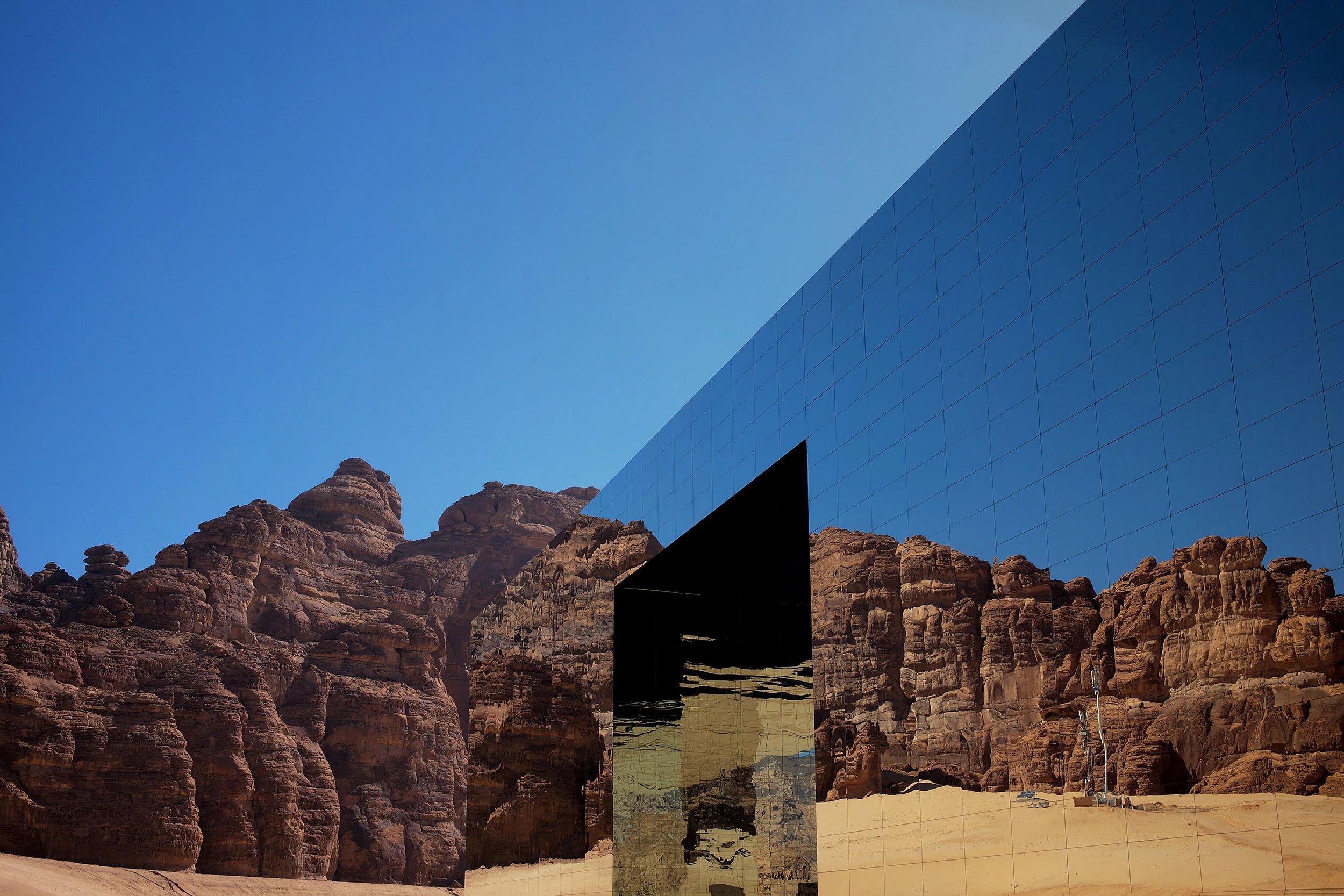 Corner of the mirrored building with its entrance cut, reflecting red sandstone cliffs – Maraya Concert Hall, AlUla, Saudi Arabia, 2019 – architecture