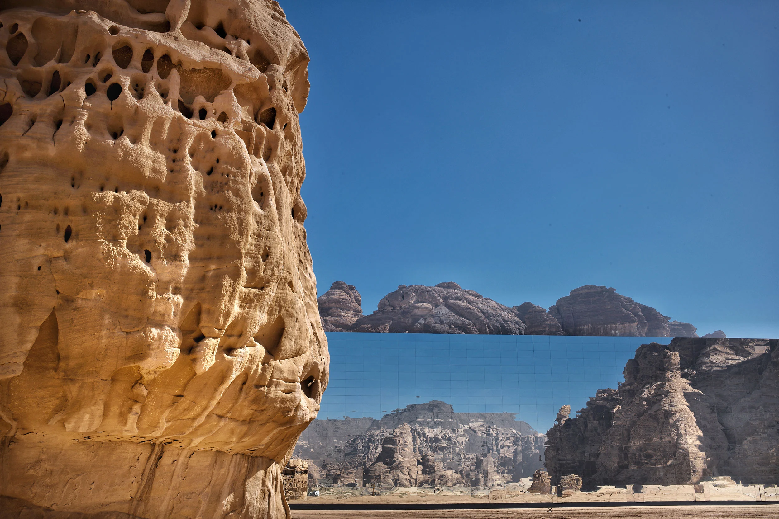 Eroded sandstone rock in the foreground and the mirrored facade reflecting the cliffs behind – Maraya Concert Hall, AlUla, Saudi Arabia, 2019 – architecture