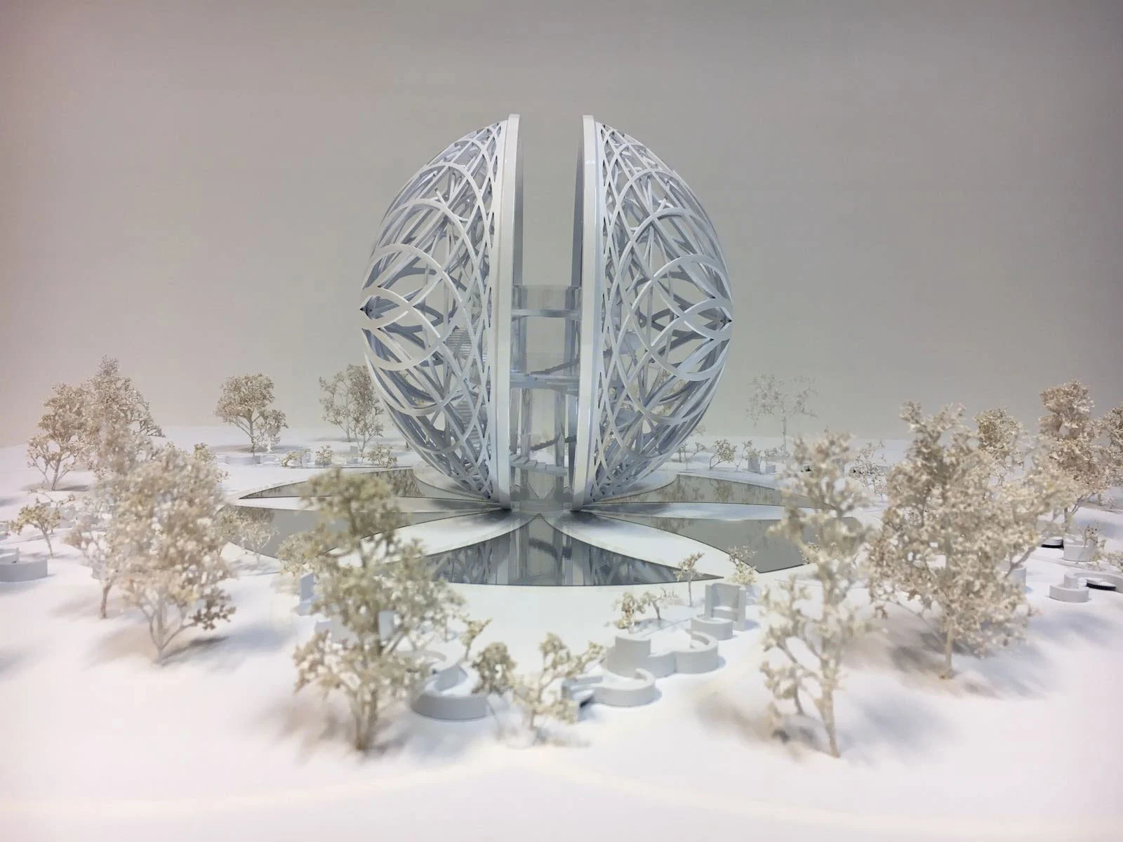 Model of the Leosphere: a white split sphere of interlaced ribs on a reflecting pool among model trees – Leosphere, Chicago, United States, 2022 – architecture concept