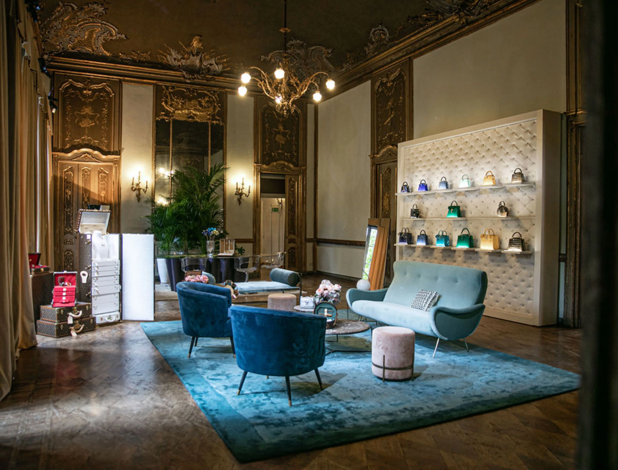 Frescoed salon with blue velvet chairs, a teal rug and a quilted wall displaying handbags – Louis Vuitton at Palazzo Clerici, Milan, Italy, 2019 – exhibition design