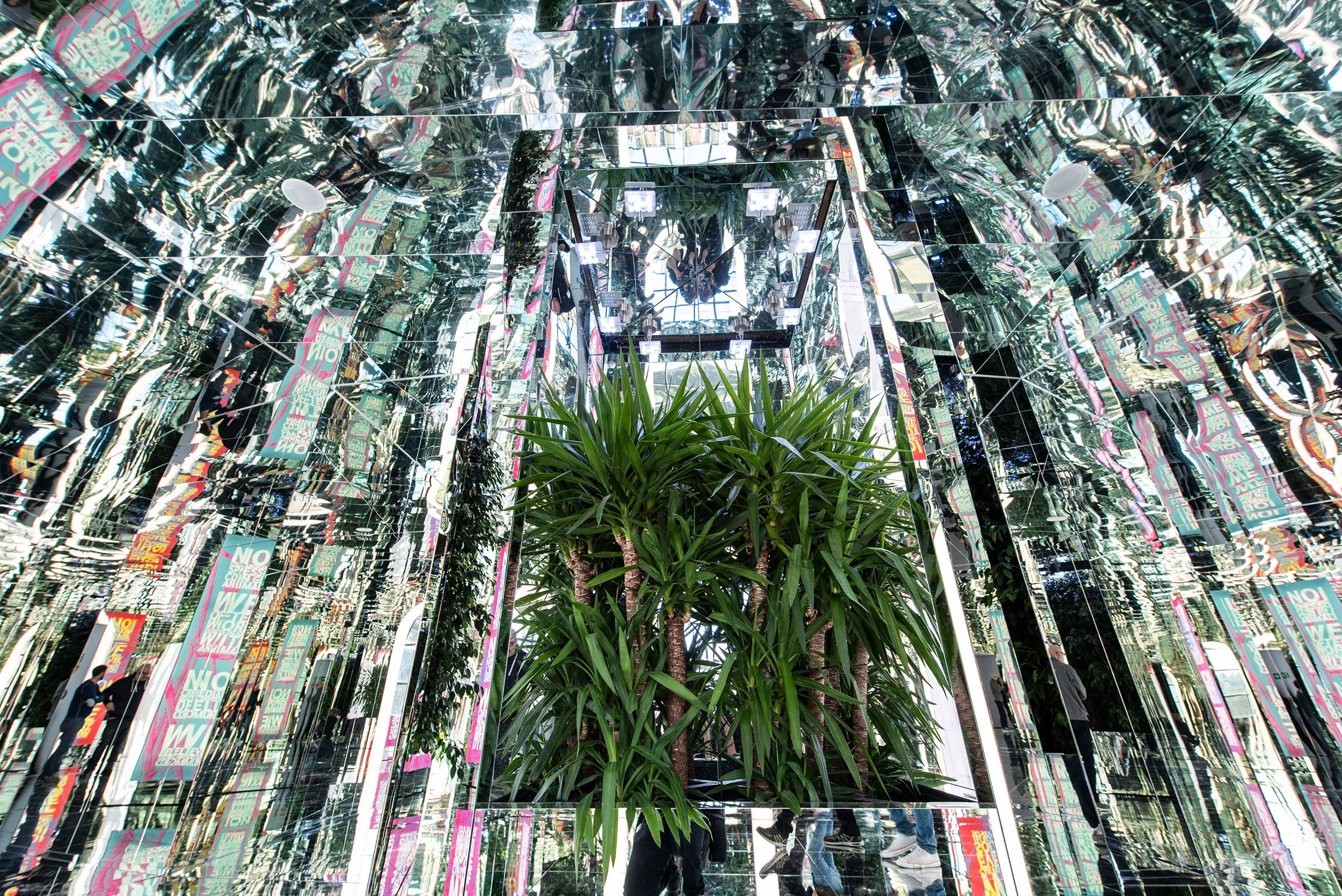 Mirrored installation reflecting a tall palm plant and exhibition graphics endlessly in all directions – La Nazione delle Piante at Triennale, Milan, Italy, 2019 – exhibition design