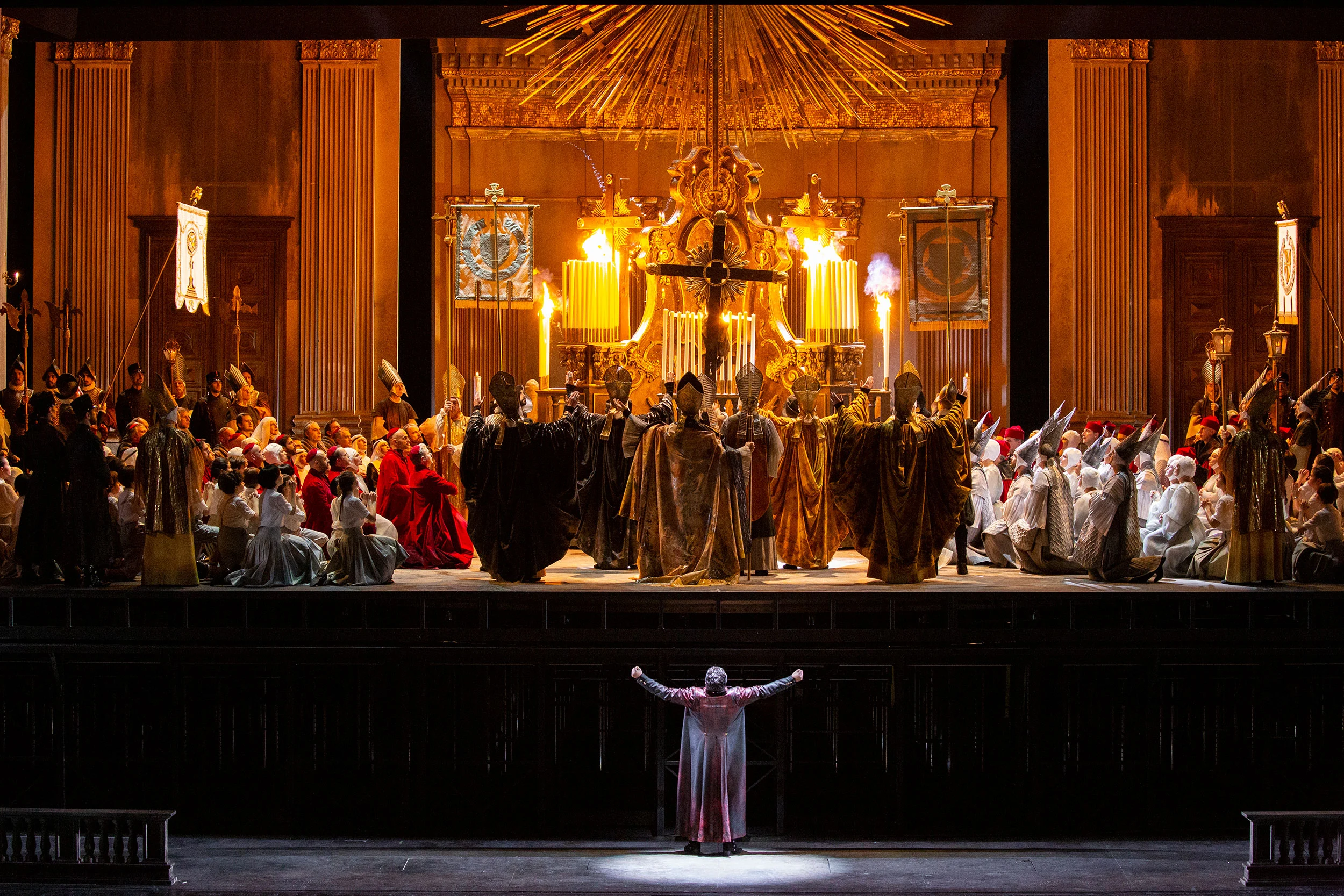 Tosca finale of Act I: a singer downstage before a crowded church scene with a golden altar and cross – Tosca at La Scala, Milan, Italy, 2019 – opera set design