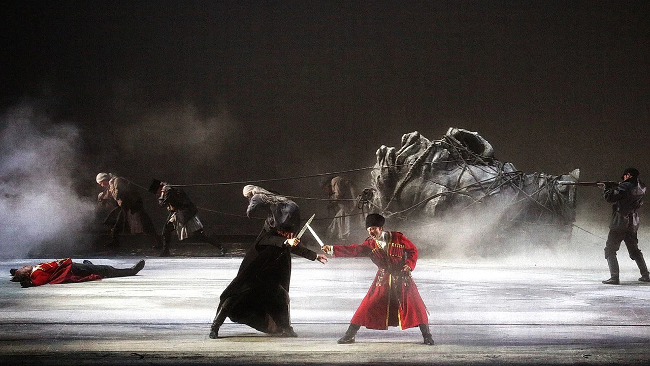 Two swordsmen fighting on a smoky stage, one in a red uniform, with a fallen horse sculpture behind – Tamerlano at La Scala, Milan, Italy, 2017 – opera set design