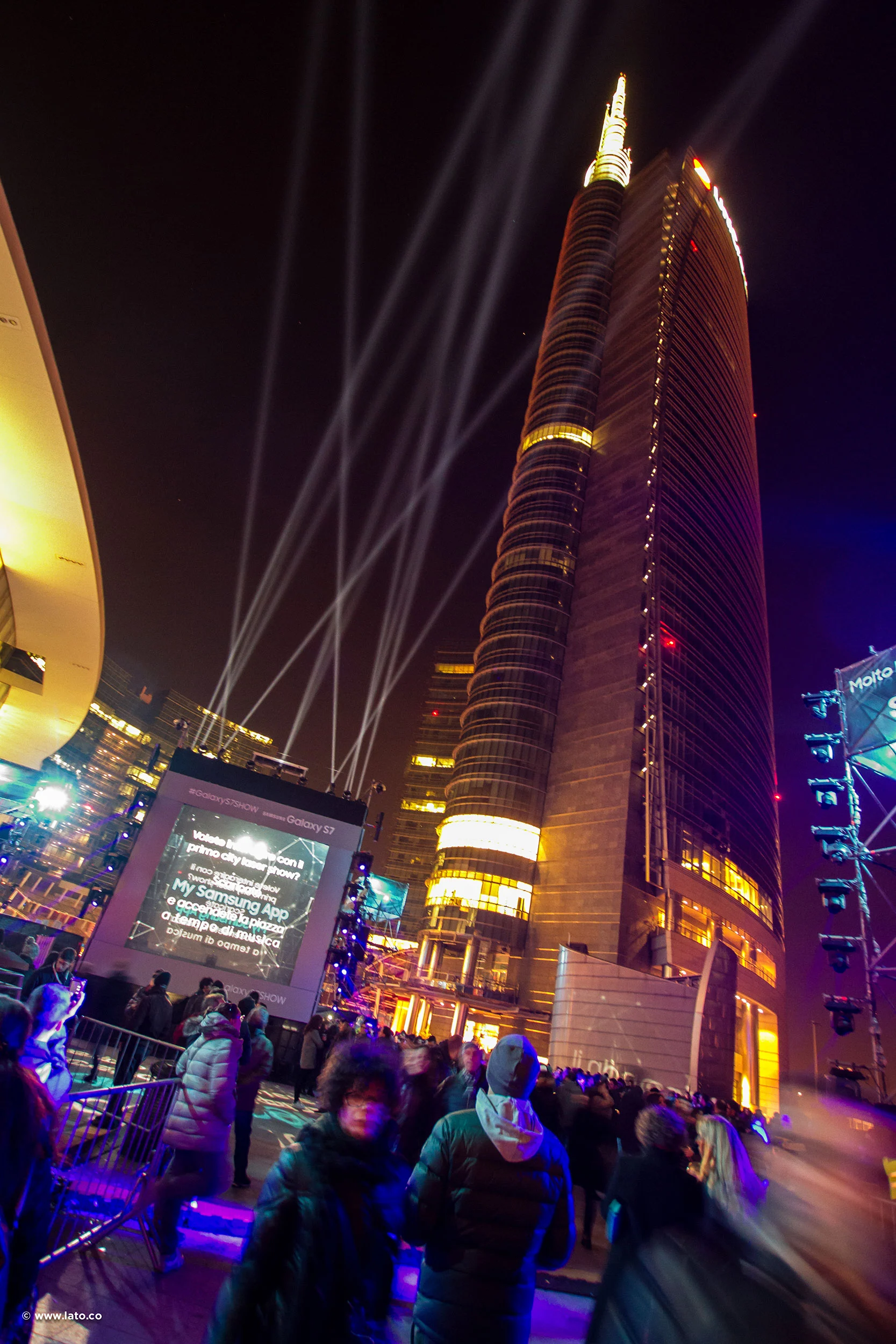 Night view of the illuminated skyscraper above Piazza Gae Aulenti, with searchlights and a large screen – Samsung Galaxy S7 Laser Show, Milan, Italy, 2016 – event design