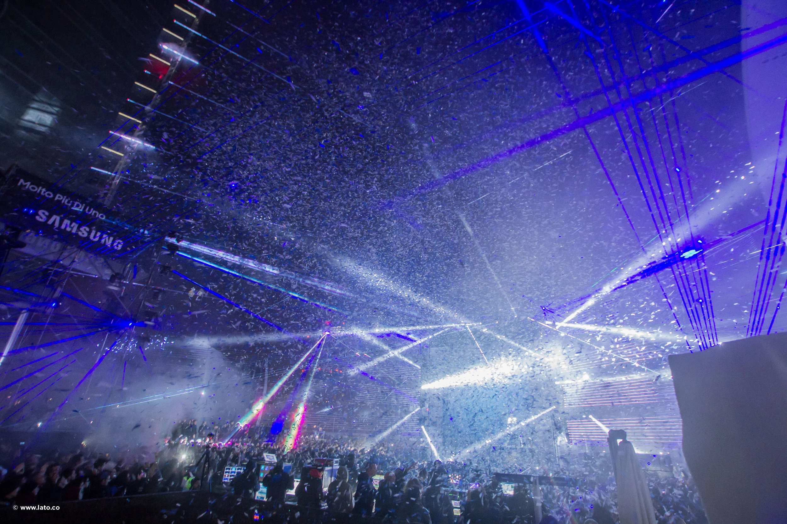 Shower of confetti and laser beams over the crowd at the Samsung show, with a branded screen at left – Samsung Galaxy S7 Laser Show, Milan, Italy, 2016 – event design