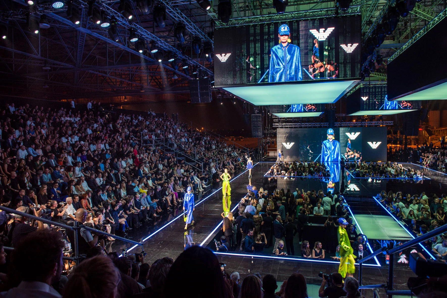 Emporio Armani Boarding show in the Linate hangar: models on lit runways under suspended video screens – Emporio Armani Boarding SS19, Milan, Italy, 2019 – fashion show set design