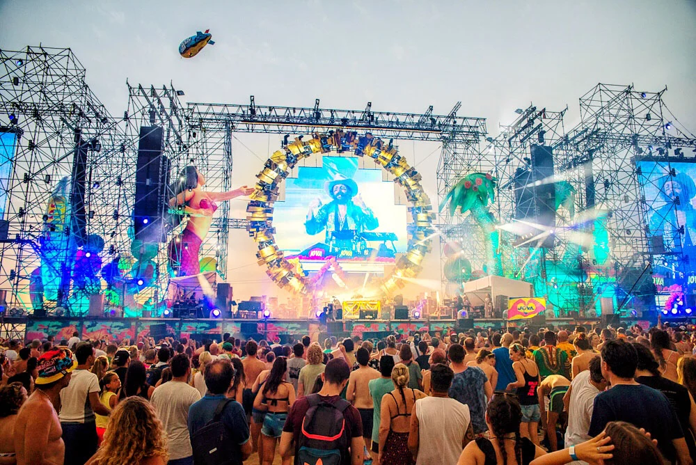 Jova Beach stage by day: ring of lights around a screen, giant mermaid and palm tree figures on scaffolding – Jova Beach Party 2019, Italy – concert stage design