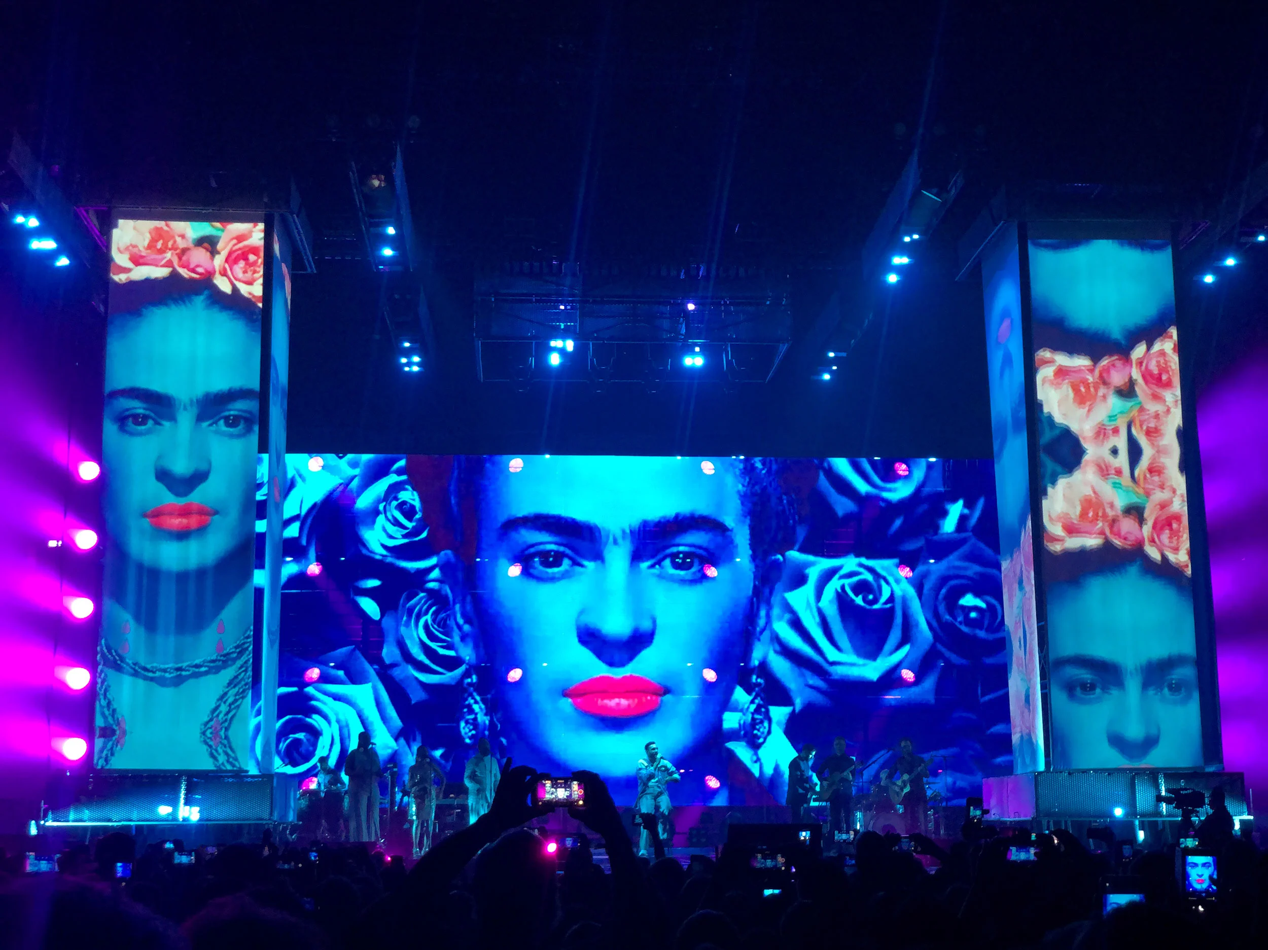 Marco Mengoni on stage under screens with a woman's portrait, red lips and blue roses – Marco Mengoni Atlantico Tour 2019, Italy – concert stage design