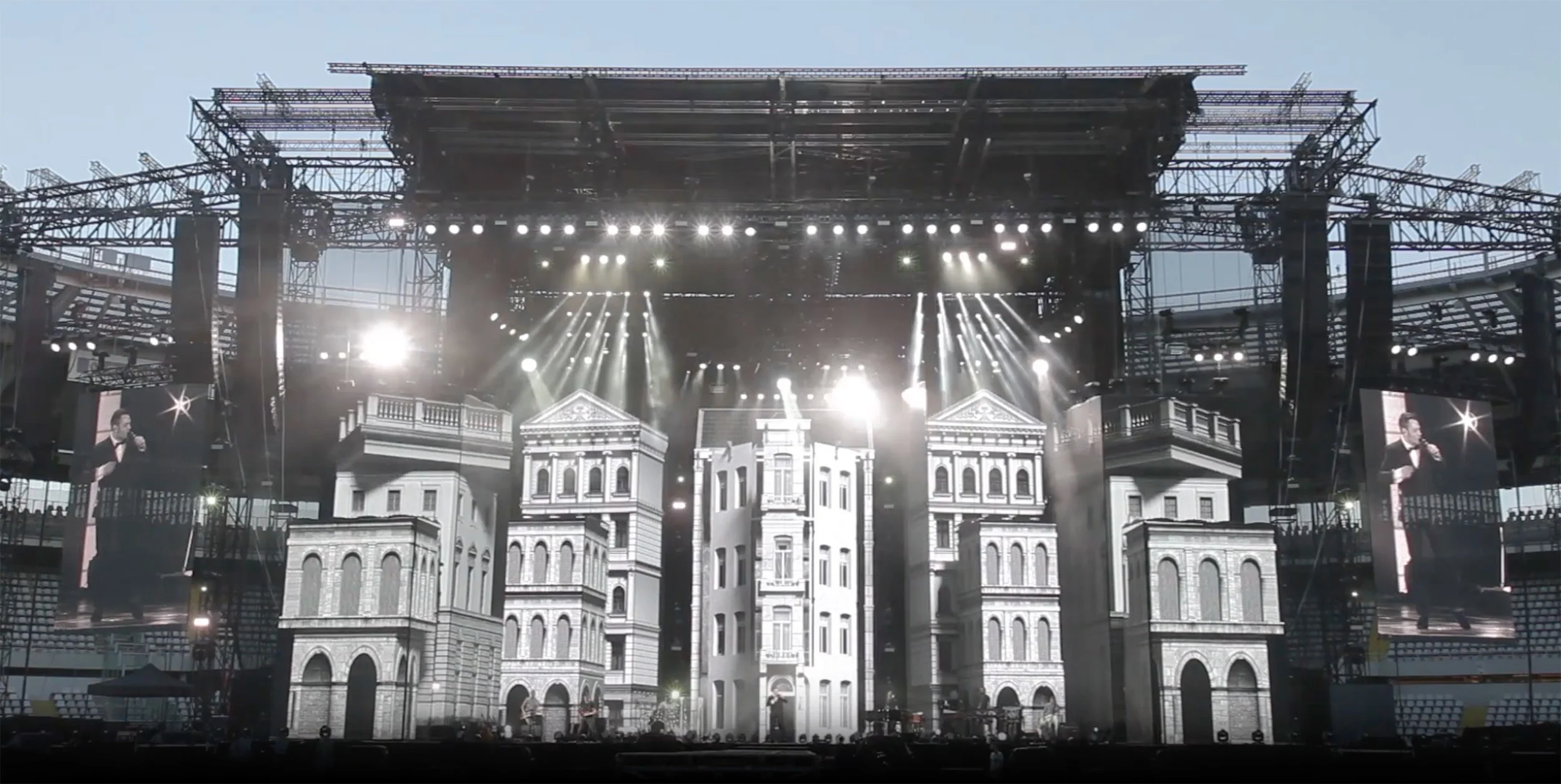 Stadium stage set built as white classical building facades, with spotlights and side screens at dusk – Tiziano Ferro Lo Stadio Tour 2015, Italy – concert stage design