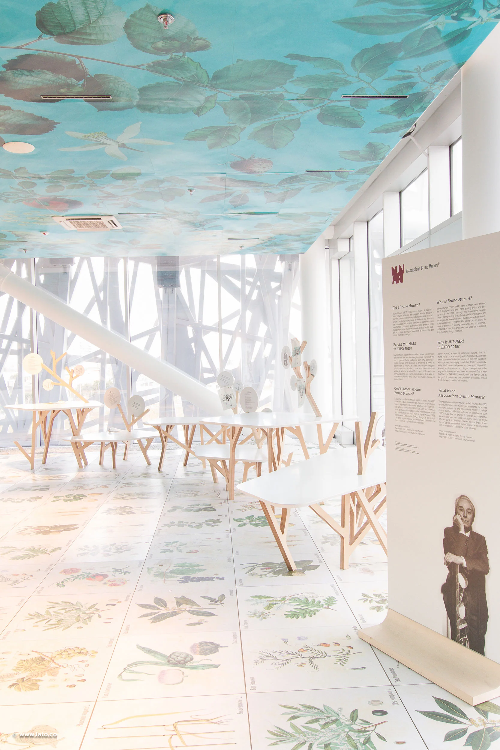 Exhibition room with a botanical ceiling mural, illustrated plant floor tiles and tree-shaped wooden tables – Italian Pavilion at Expo 2015, Milan, Italy – exhibition design