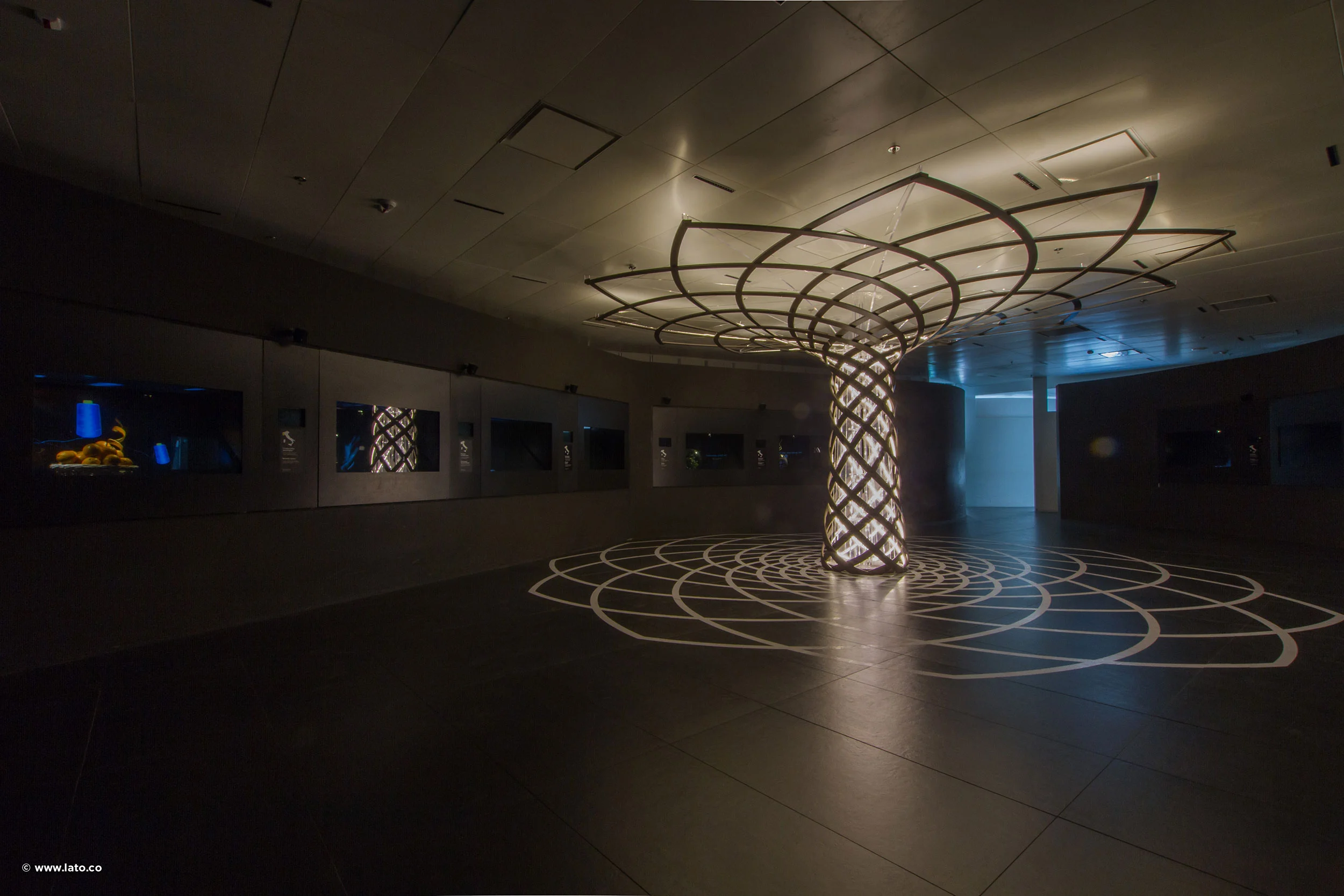 Dark exhibition hall with a backlit lattice column shaped like the Tree of Life and its projected outline – Italian Pavilion at Expo 2015, Milan, Italy – exhibition design