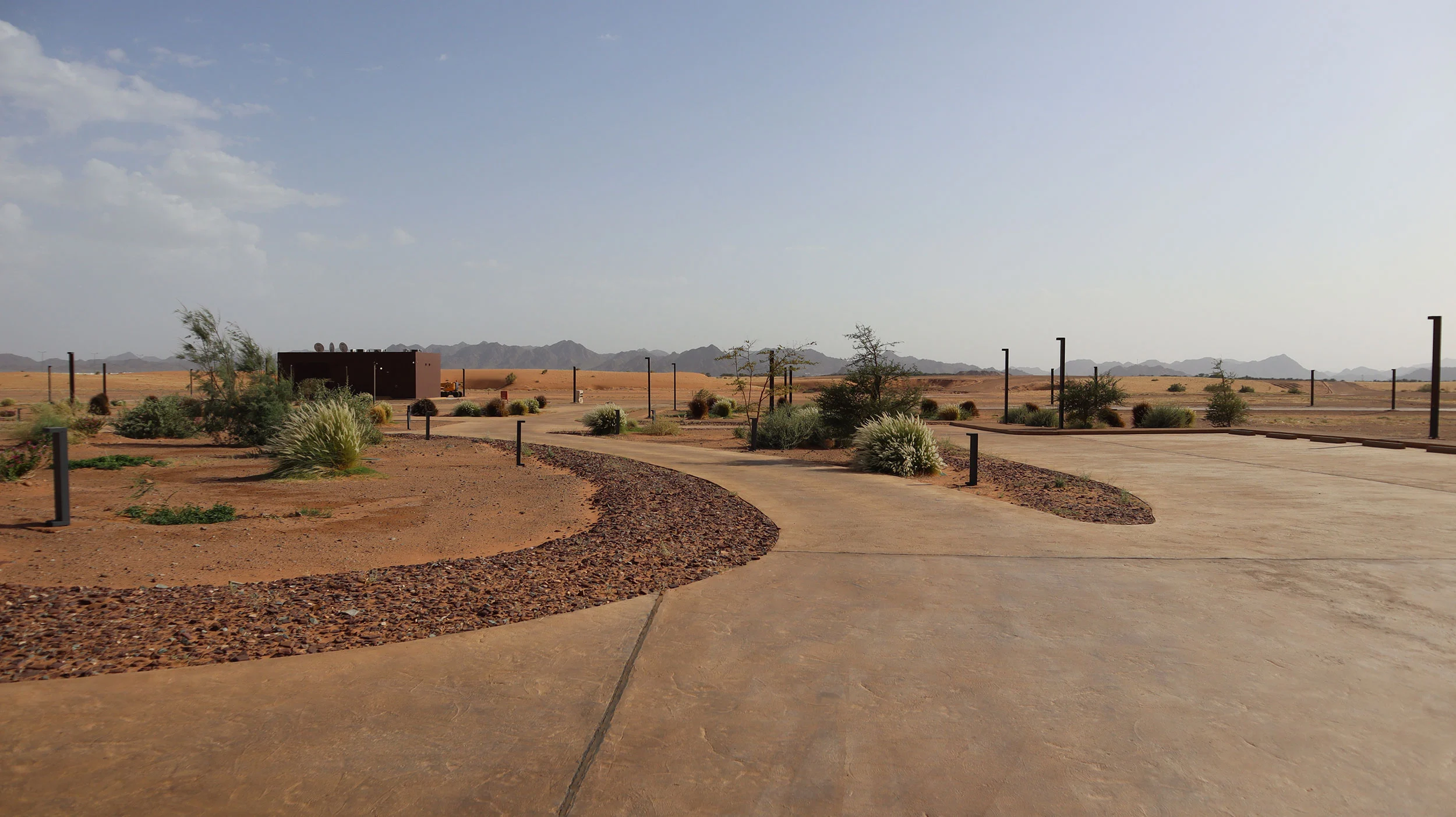 Landscaped forecourt with curving paths, gravel beds and desert plants, mountains on the horizon – Prince Abdul Majeed bin Abdulaziz Airport, AlUla, Saudi Arabia, 2021 – architecture