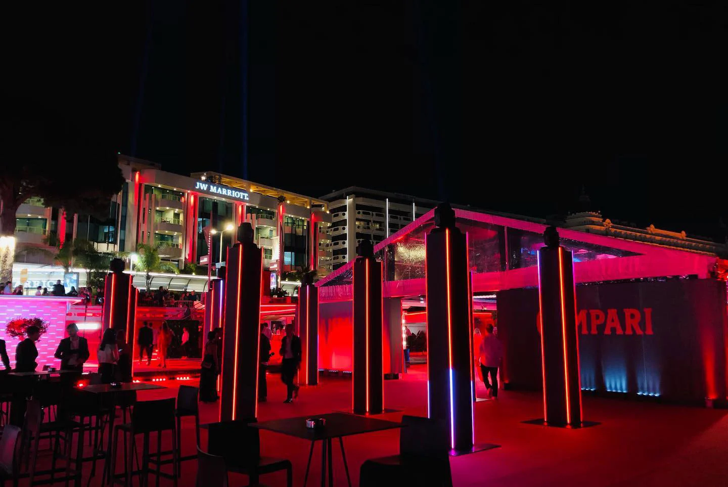 Night view of the Campari terrace with illuminated columns and a red-lit pavilion, hotel facade behind – Campari at the 75th Cannes Film Festival, France, 2022 – event design