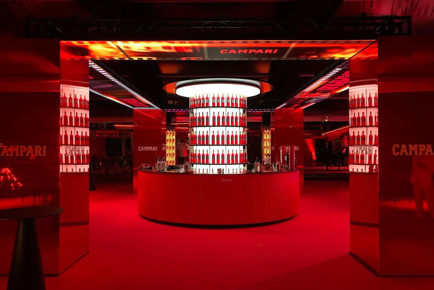 Frontal view of the round Campari bar framed by red columns and an LED lintel with the brand name – Campari at the 75th Cannes Film Festival, France, 2022 – event design