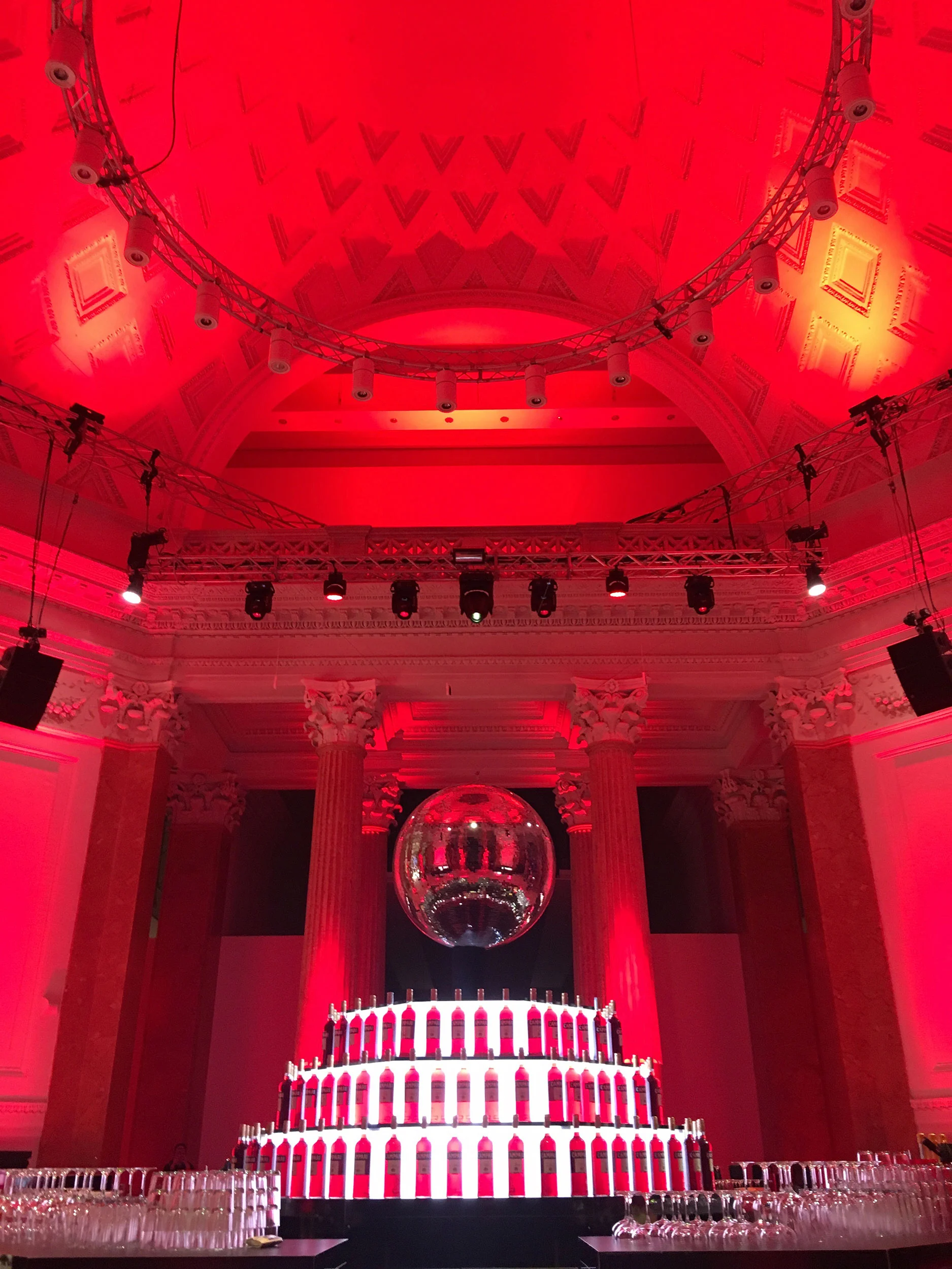 Domed hall in red light with a mirror ball above a tiered display of Campari bottles – Campari Red Diaries, Milan, Italy, 2017 – event design