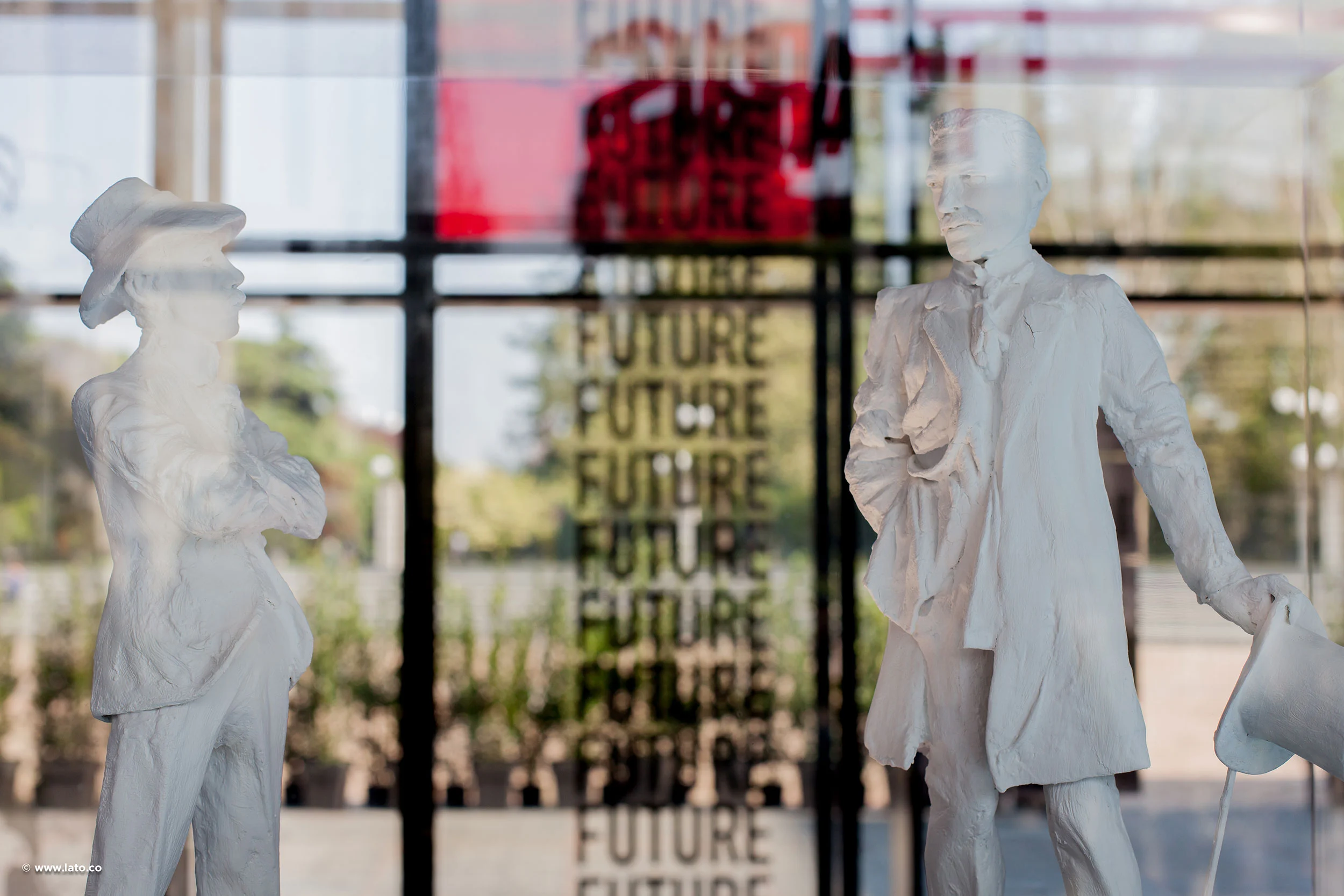 White statuettes of two figures in front of a glass wall printed with the word Future – Cartier The Legendary Thrill, Milan, Italy, 2018 – event design