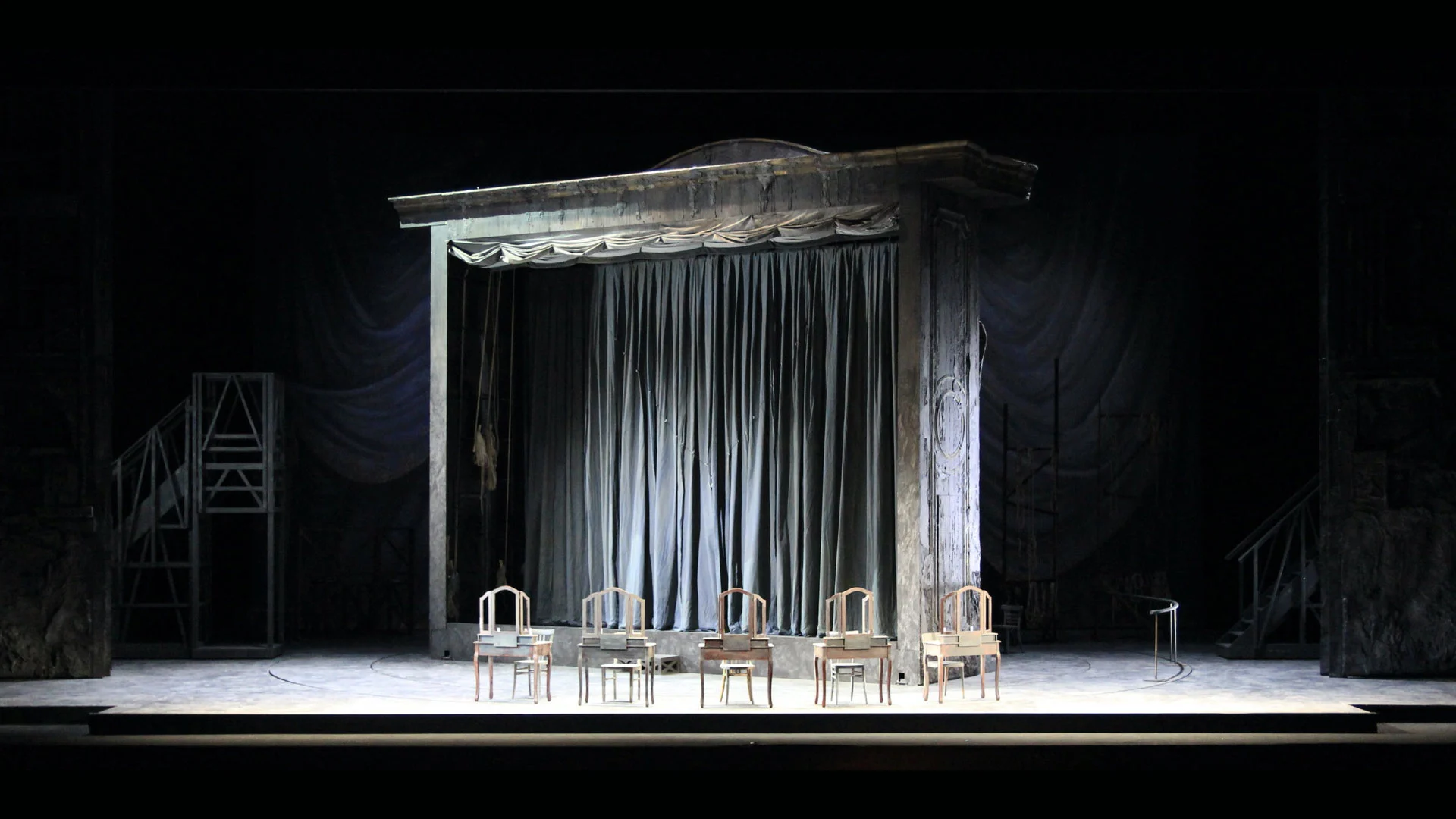 Theatre-within-a-theatre set: weathered portal with grey curtain and a row of dressing tables – Adriana Lecouvreur at Opéra de Monte-Carlo, Monte Carlo, Monaco, 2026 – set design