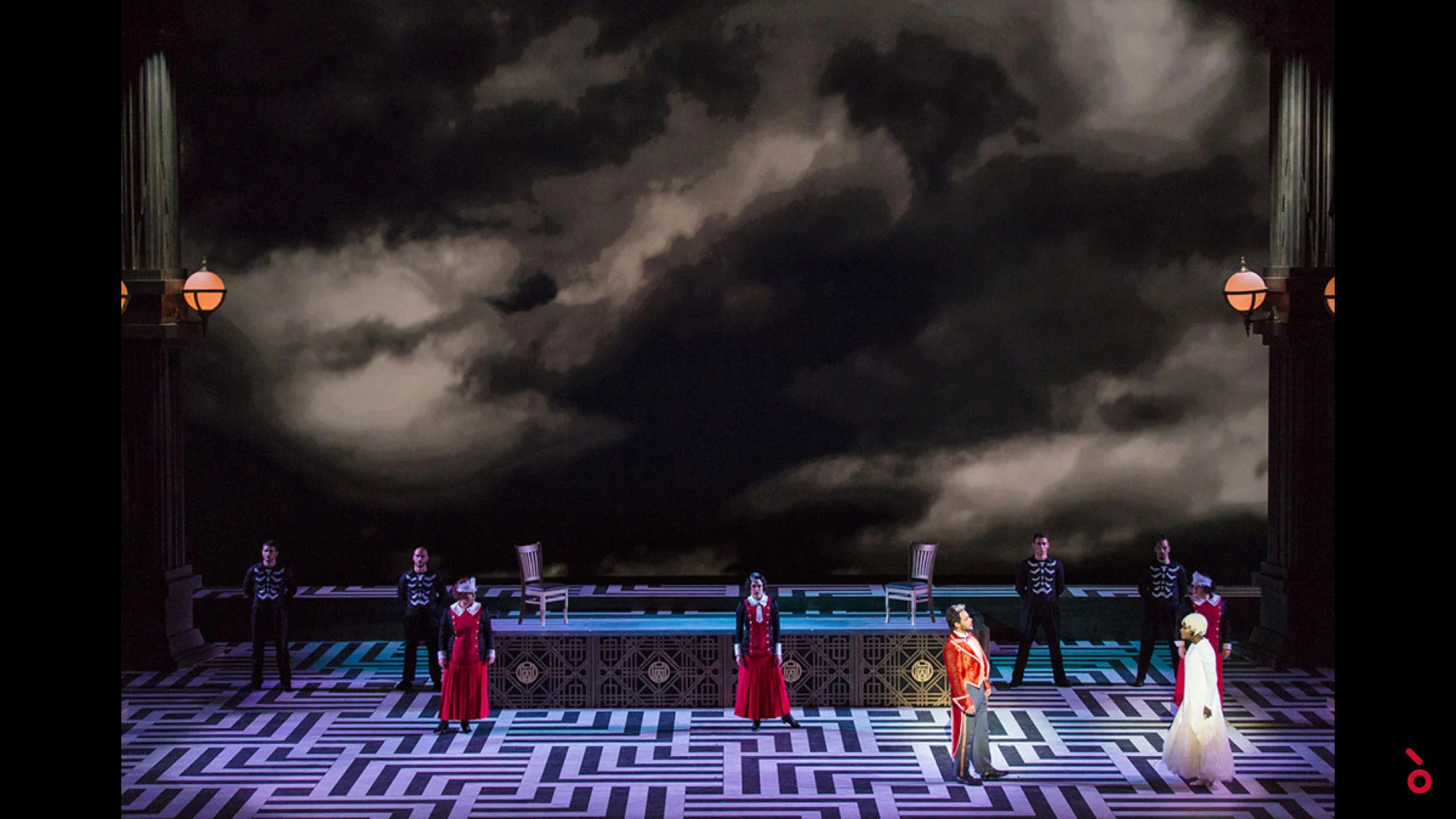 Performers lined up on a maze-patterned floor under a huge projection of dark stormy clouds – The Opera! at the Royal Opera House Muscat, Oman, 2019 – set design