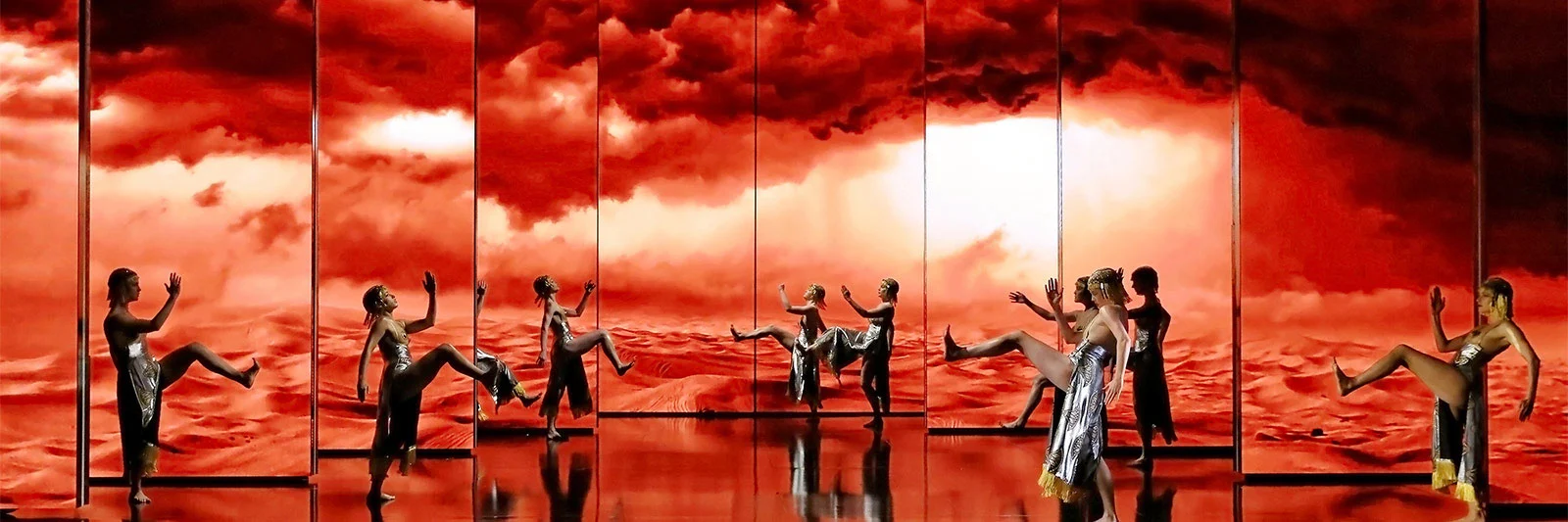 Dancers in a row before ten screens showing red desert dunes and fiery clouds – Aida at Sydney Opera House, Australia, 2018 – set design