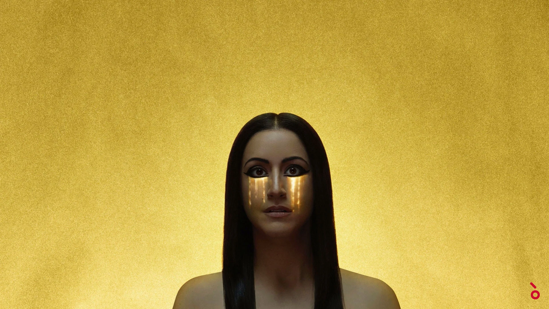 Video artwork of a woman with Egyptian eye makeup and golden tears against a gold background – Aida at Sydney Opera House, Australia, 2018 – set design