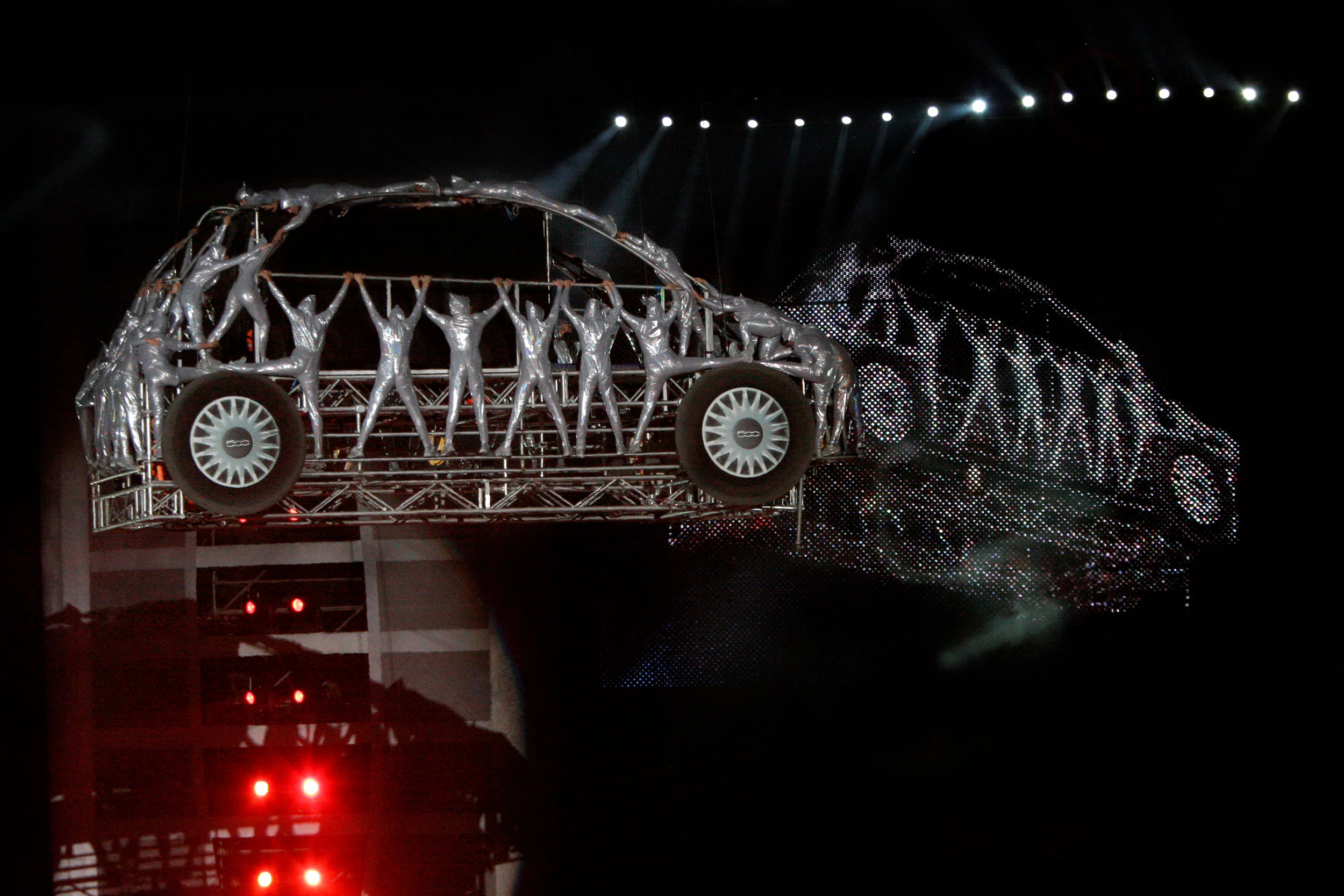 Performers in silver suits posed inside a suspended Fiat 500 frame, forming a human car – Fiat Welcome 500 World Premiere, Turin, Italy, 2007 – event design