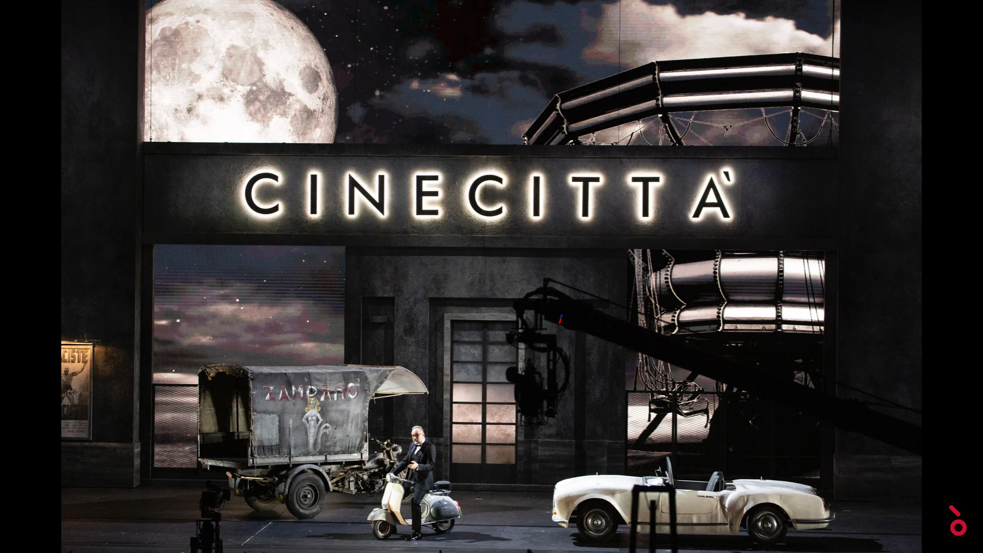 Set with an illuminated Cinecittà sign, a full moon, a scooter, a vintage van and a white convertible – A Riveder le Stelle at La Scala, Milan, Italy, 2020 – opera set design