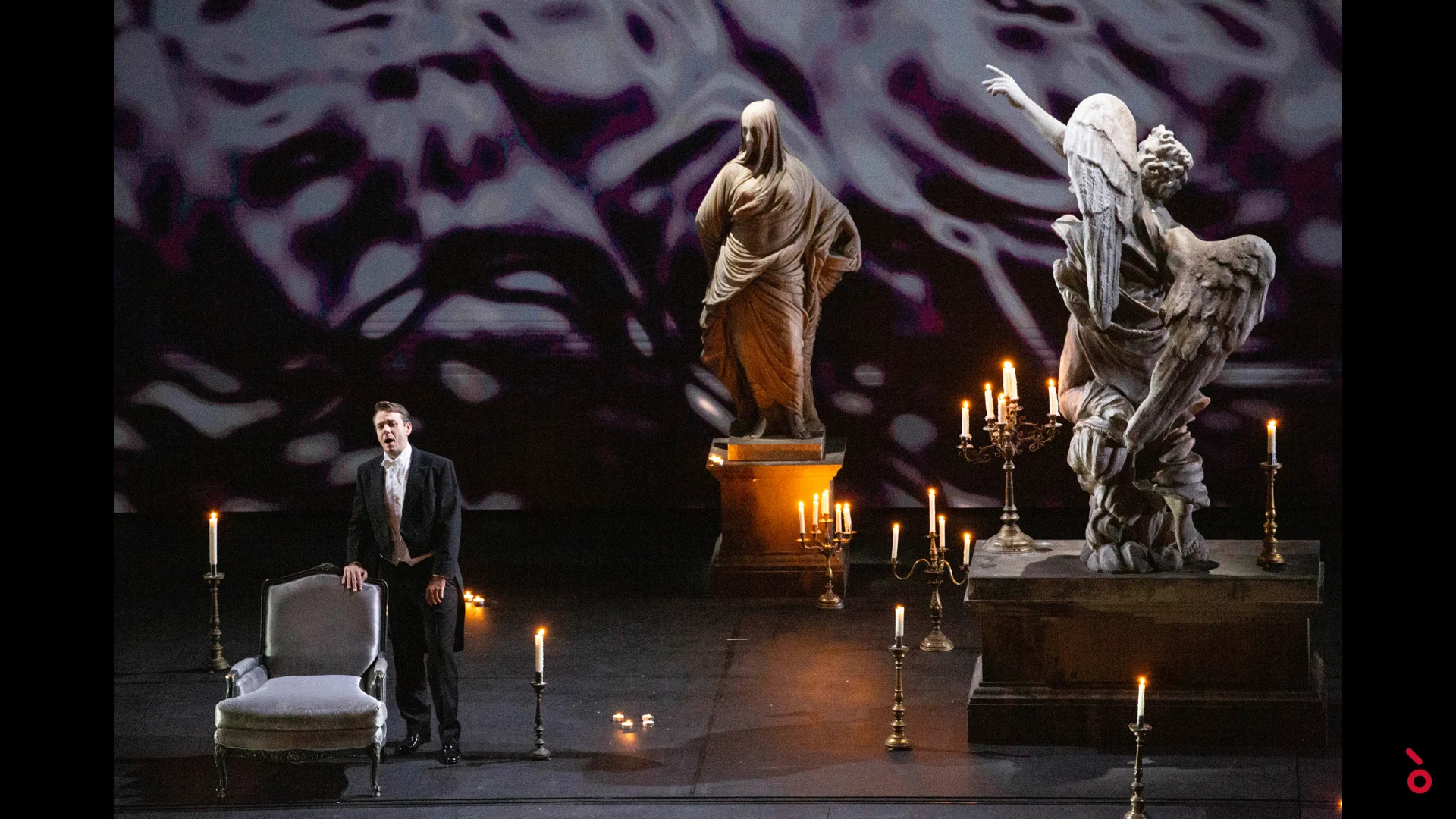 Singer beside an armchair among candles and marble statues, rippling light projected behind – A Riveder le Stelle at La Scala, Milan, Italy, 2020 – opera set design
