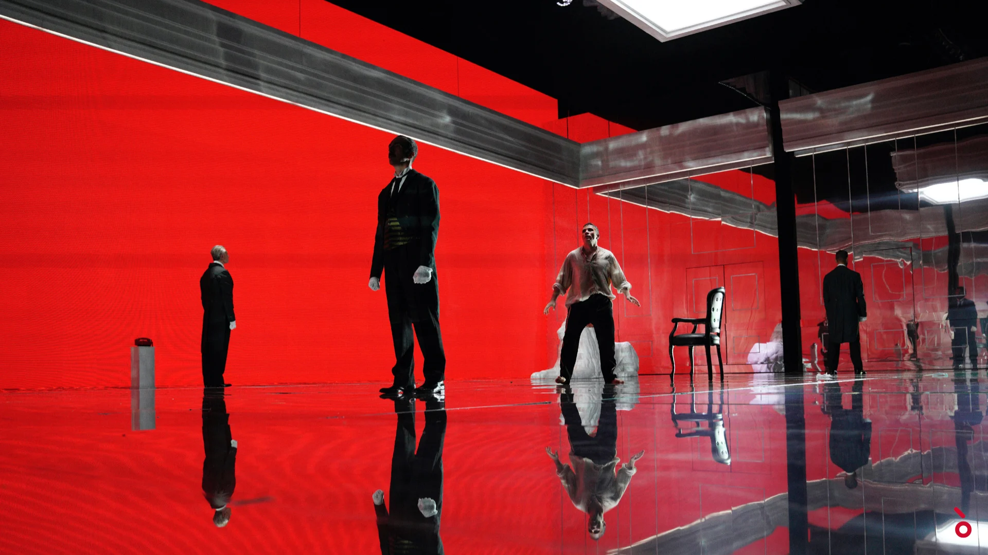 Performers on a mirrored floor against a vivid red LED wall, with a chair and a white statue – Elisabetta, Regina d'Inghilterra at Rossini Opera Festival, Pesaro, Italy, 2021 – set design