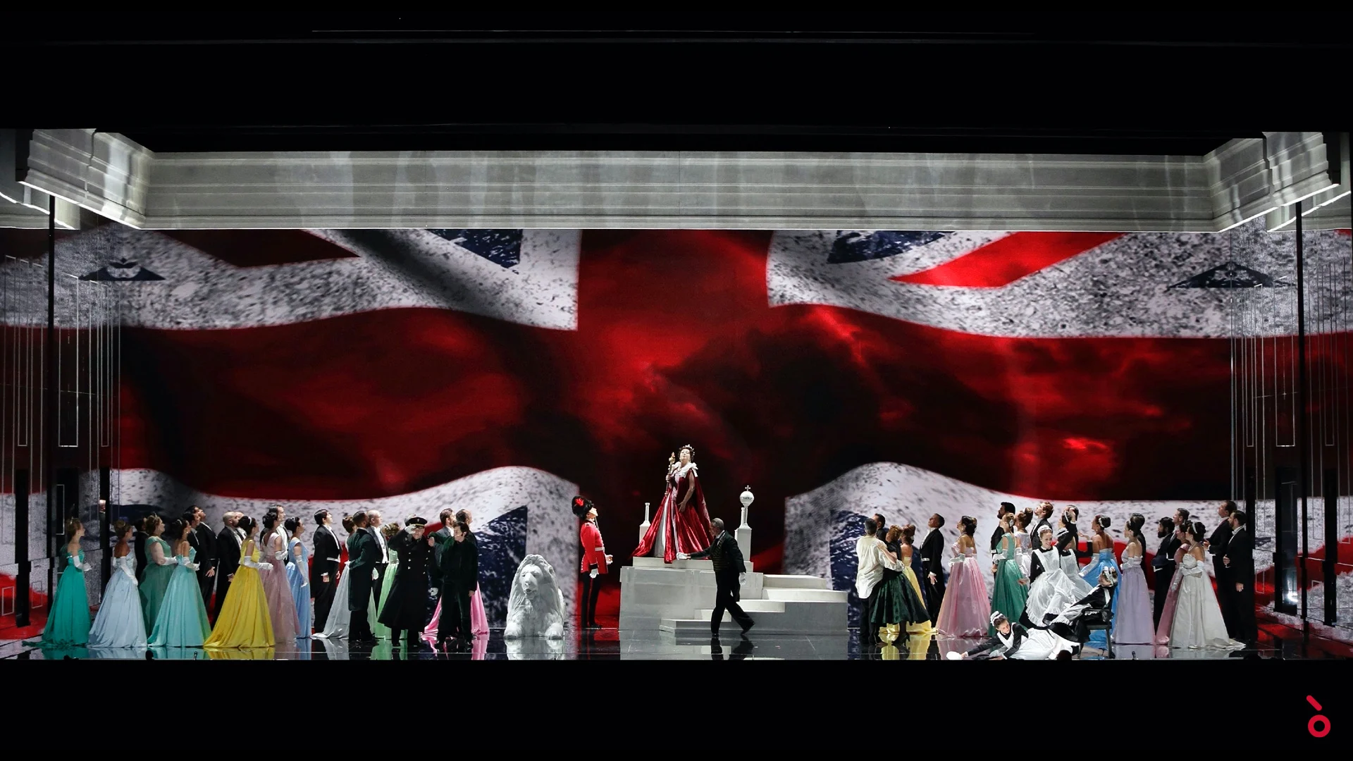 Full cast in coloured gowns before a giant Union Jack projection, the queen on white steps – Elisabetta, Regina d'Inghilterra at Rossini Opera Festival, Pesaro, Italy, 2021 – set design