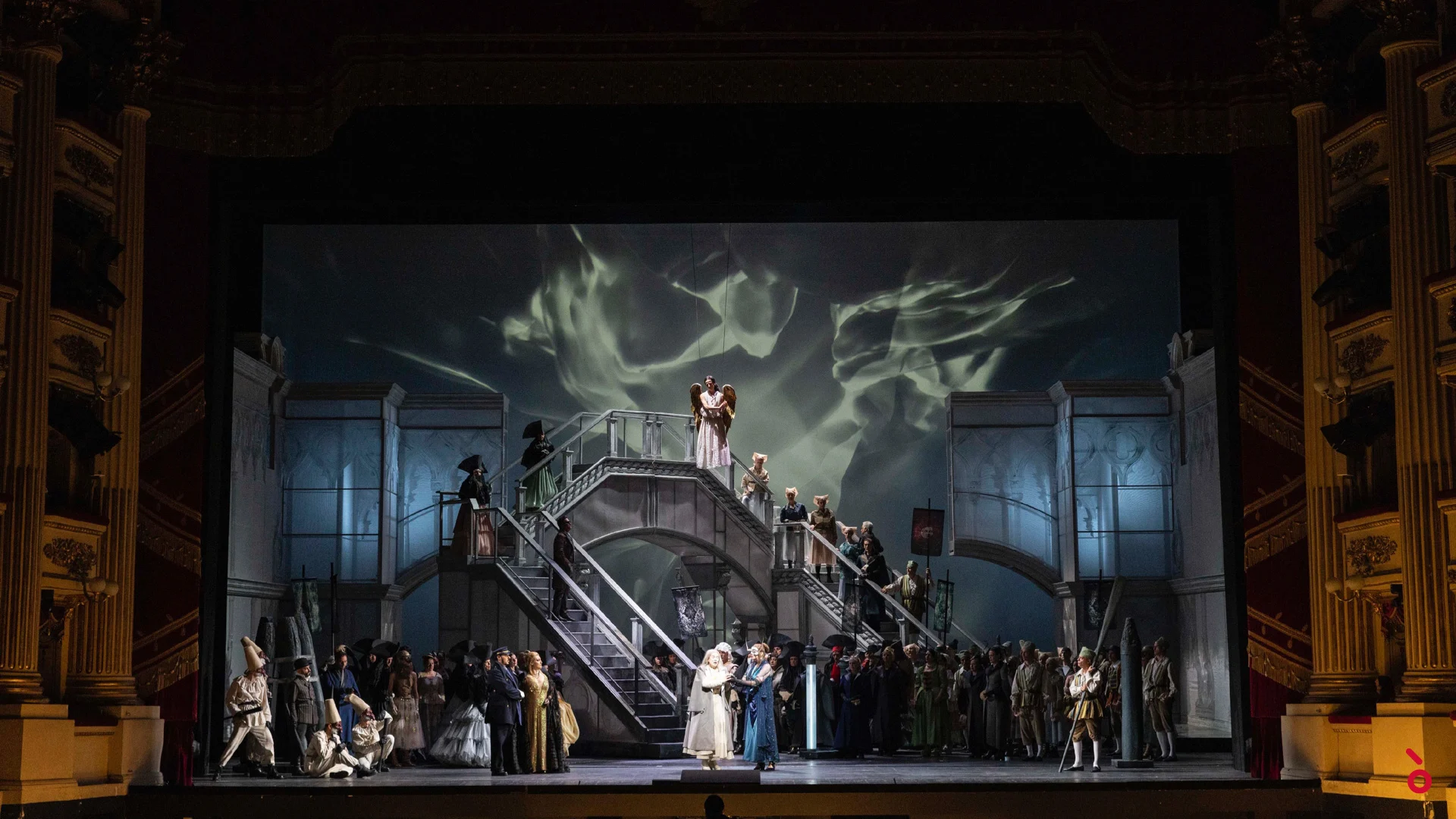 Chorus crowding a grand double staircase set, with swirling smoke-like projections on the backdrop – La Gioconda at La Scala, Milan, Italy, 2022 – opera set design