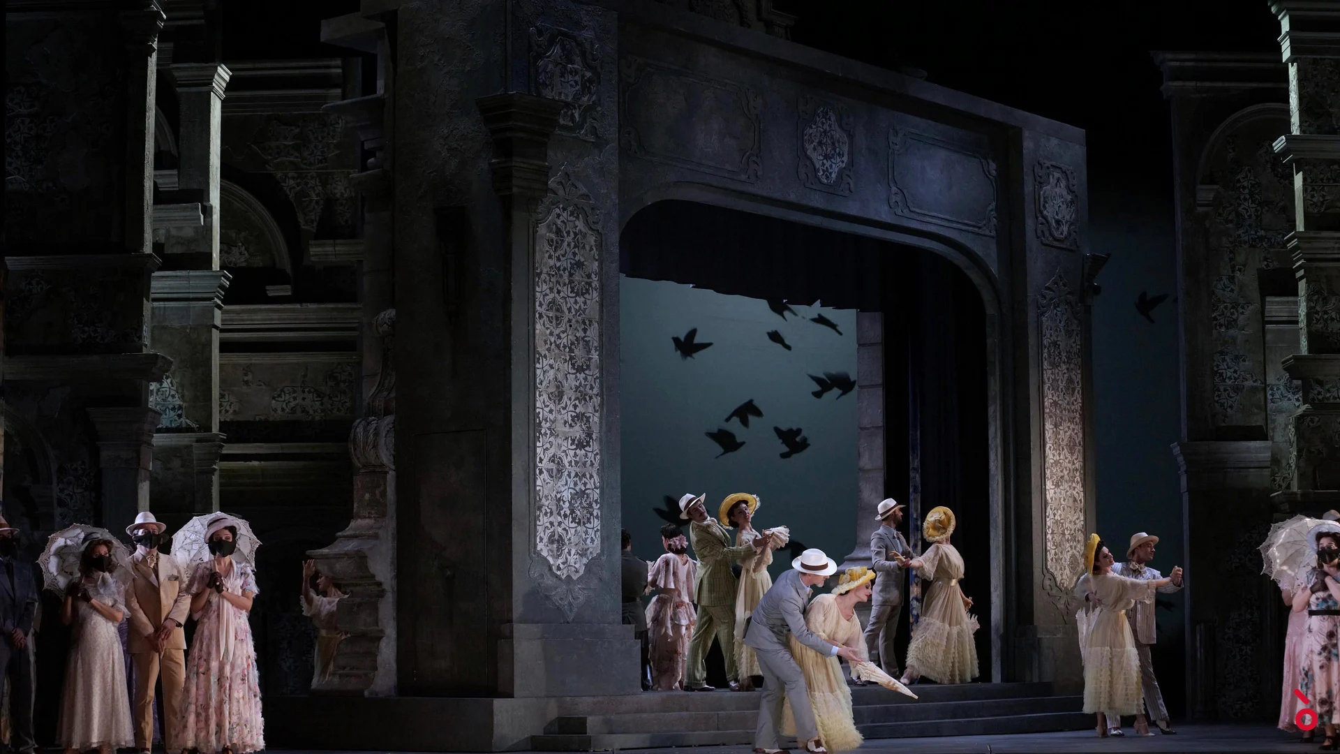 Ornate cinema-facade set with a large arch, chorus in period costumes and parasols, birds projected behind – Luisa Fernanda at Teatro de la Zarzuela, Madrid, Spain, 2021 – opera set design
