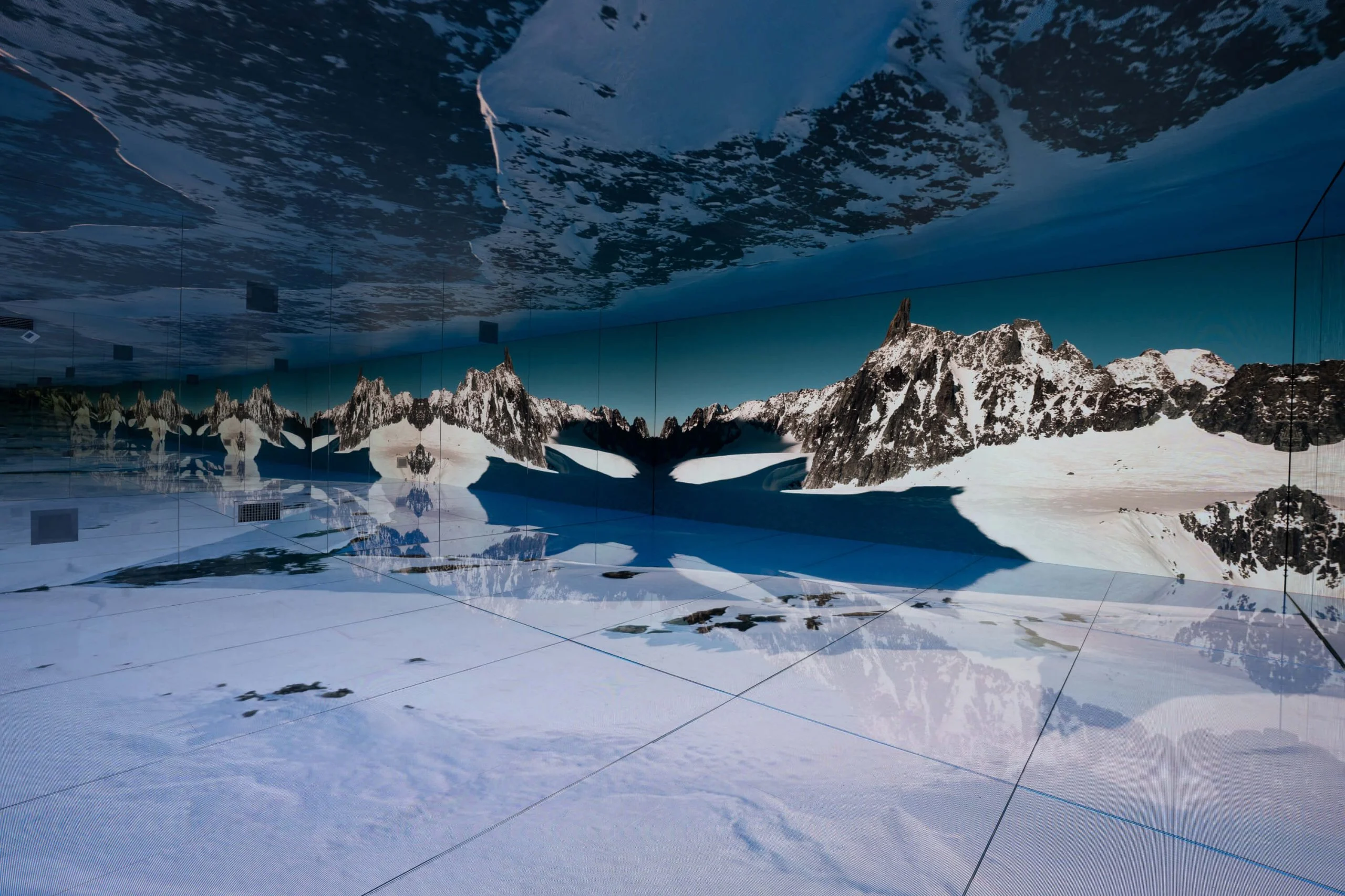 Snowy glacier on the LED floor and walls, with jagged peaks repeated endlessly in the mirrors – Mont Blanc Infinity Room at Skyway, Courmayeur, Italy, 2023 – installation design