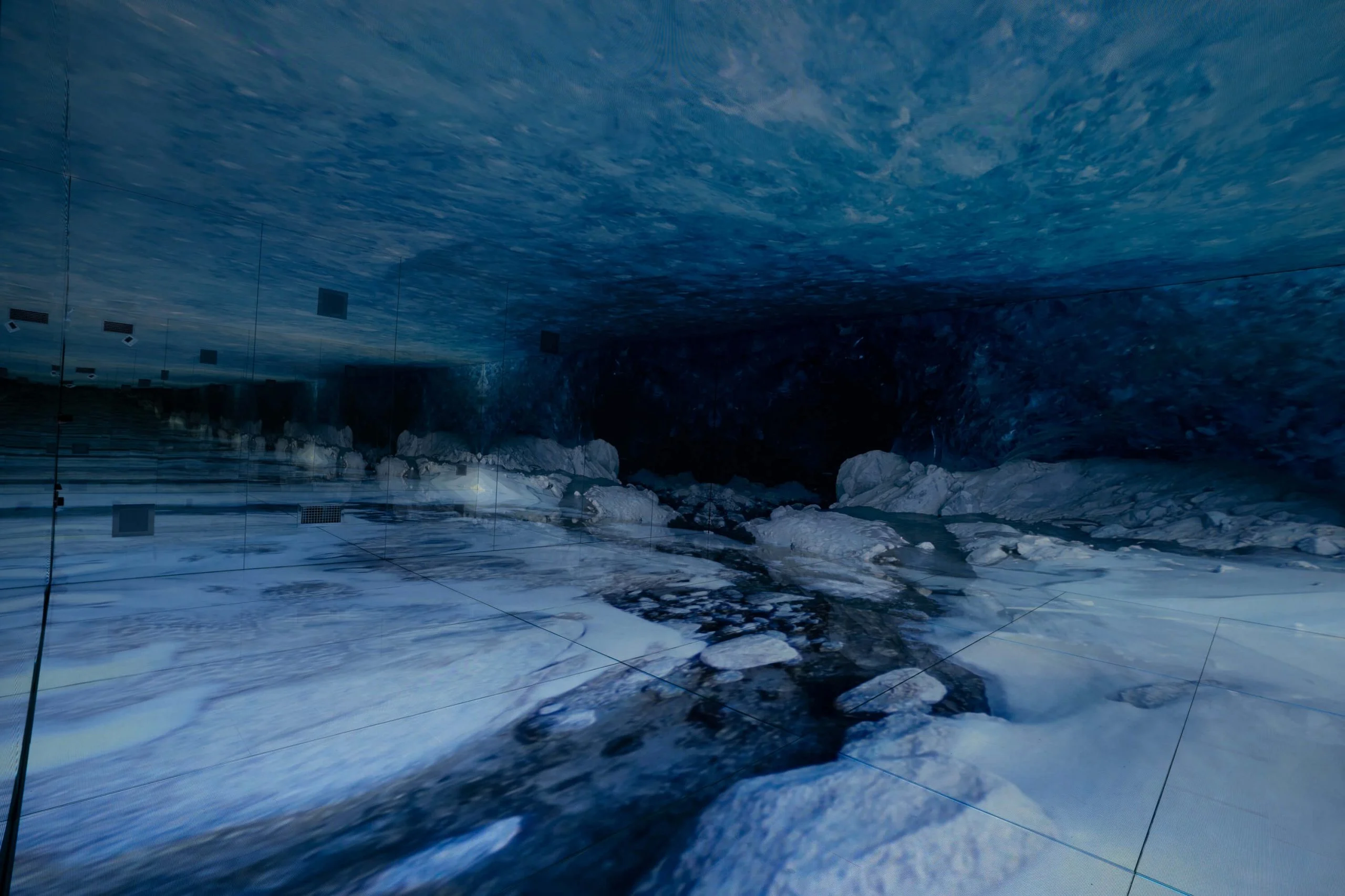 Immersive room recreating a blue glacial cave, with ice blocks shown on the LED floor and ceiling – Mont Blanc Infinity Room at Skyway, Courmayeur, Italy, 2023 – installation design