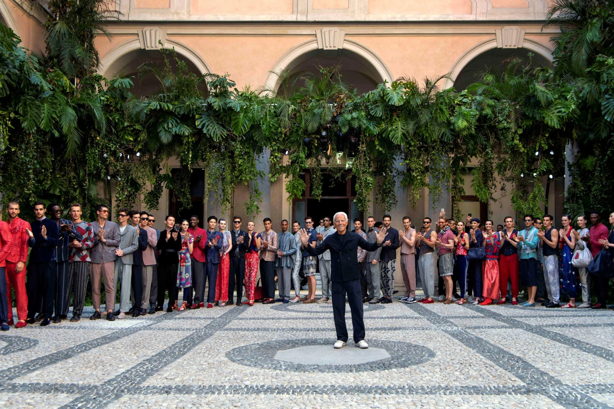 Designer and models lined up for the finale in the cloister under arches draped with plants – Giorgio Armani SS20 Men and Women, Milan, Italy, 2019 – fashion show set design