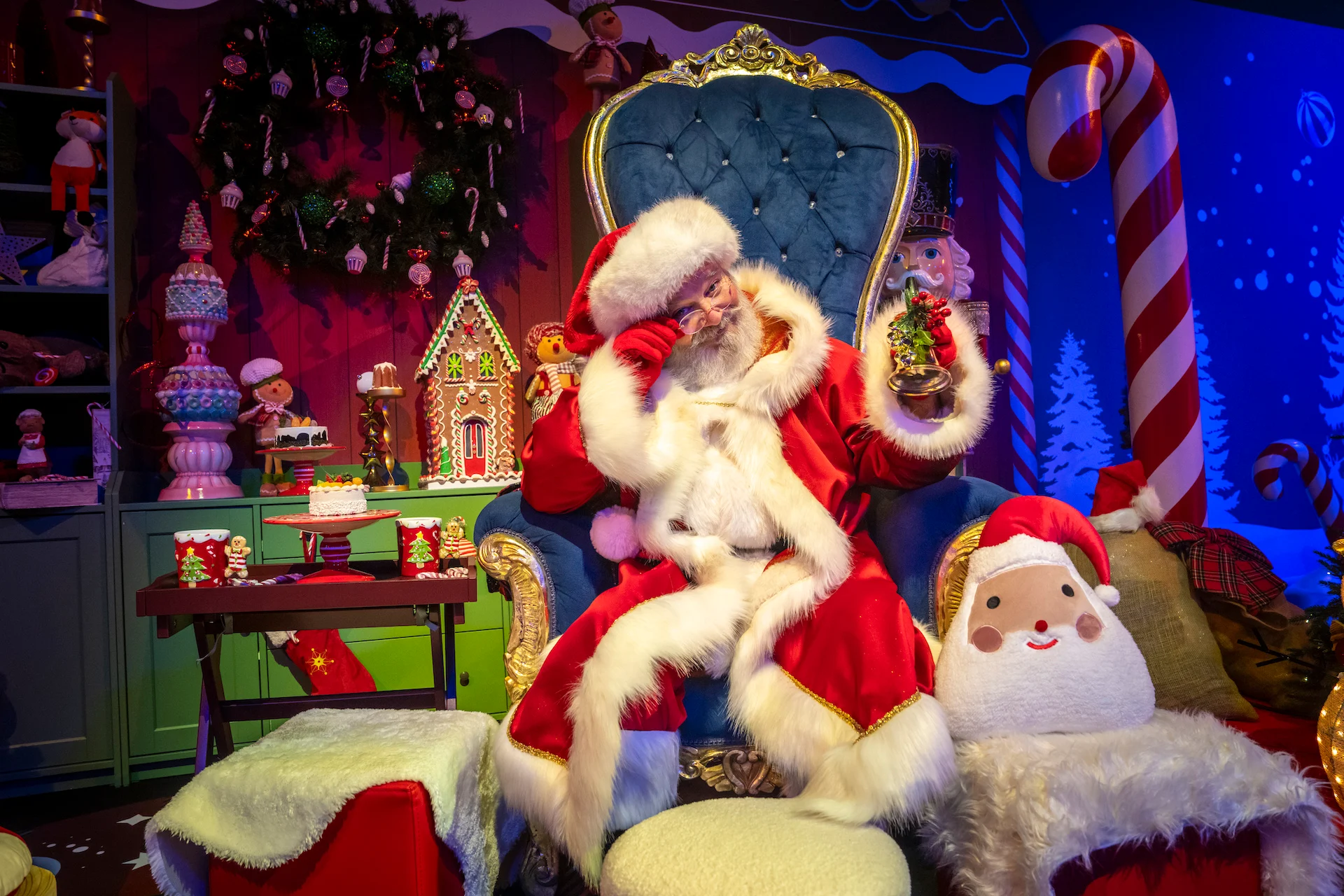 Santa Claus on a blue velvet throne in a cosy set with candy canes, toys and a gingerbread house – A Christmas Magic at Allianz MiCo, Milan, Italy, 2023 – event design