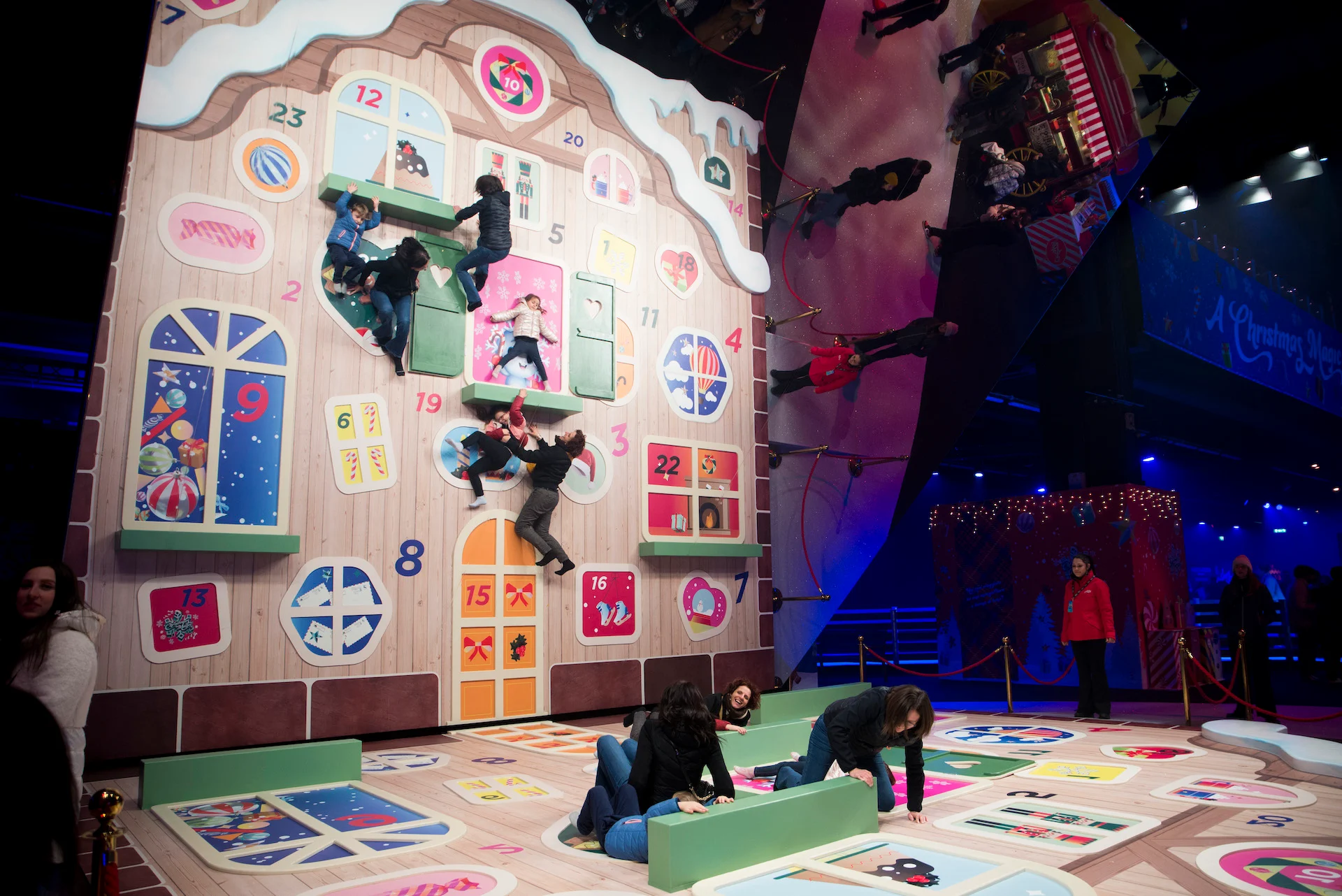 Visitors posing on a giant advent calendar facade laid on the floor, with a mirror creating an illusion – A Christmas Magic at Allianz MiCo, Milan, Italy, 2023 – event design