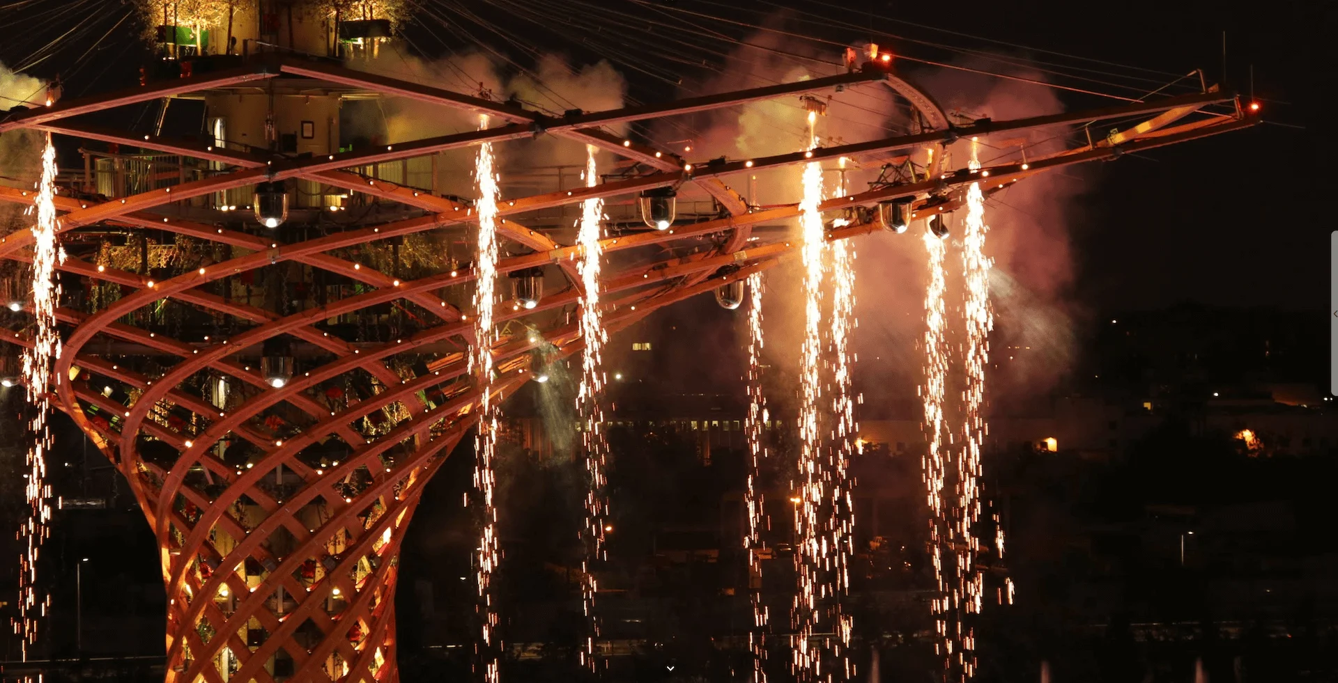 Close-up of the wooden lattice trunk and crown of the Tree of Life with fireworks cascading at night – Albero della Vita at Expo 2015, Milan, Italy – installation design