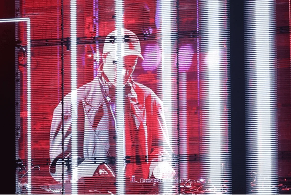 DJ seen through a transparent red LED screen with vertical white light strips – Campari Discover Red Party at Cannes Film Festival, France, 2023 – event design