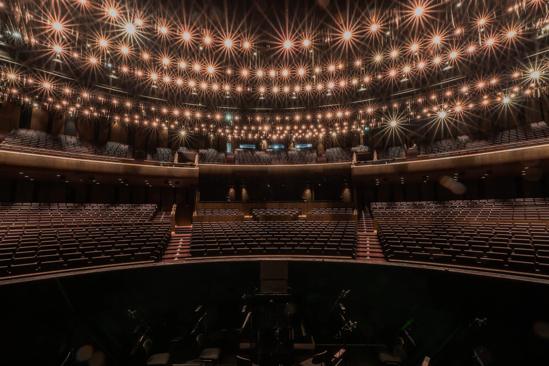 Auditorium seen from the stage, empty stalls and balconies under a ceiling of starburst lights – King Fahad Cultural Center, Riyadh, Saudi Arabia, 2024 – architectural renovation