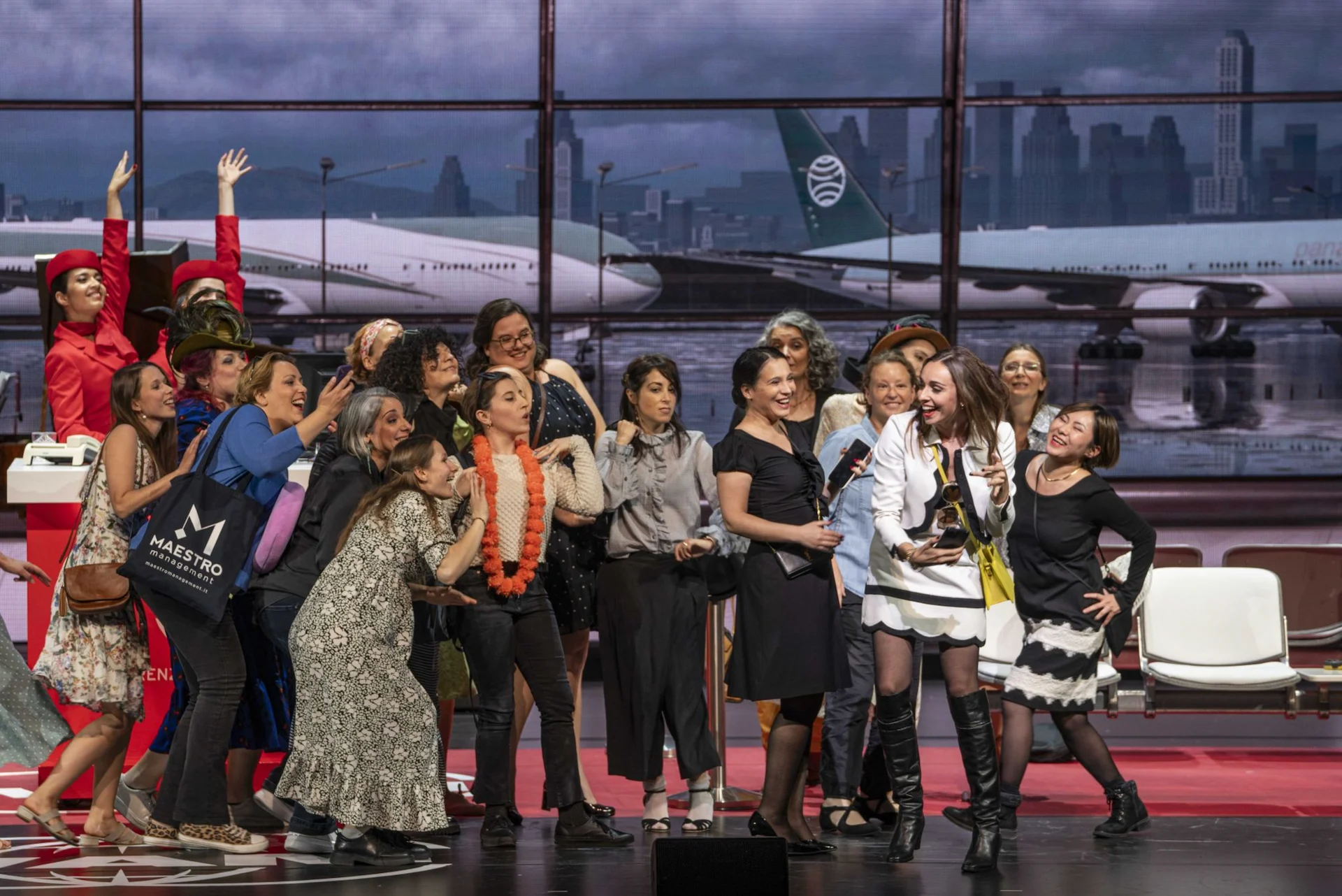 Group of women in the terminal gathering around a singer in a black and white outfit – Une Folle Journée Mozart Gala, Salzburg, Austria, 2024 – opera set design