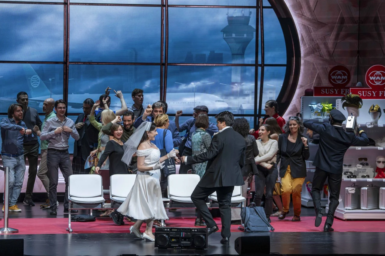 Bride and groom dancing among cheering passengers in front of the terminal window and control tower – Une Folle Journée Mozart Gala, Salzburg, Austria, 2024 – opera set design