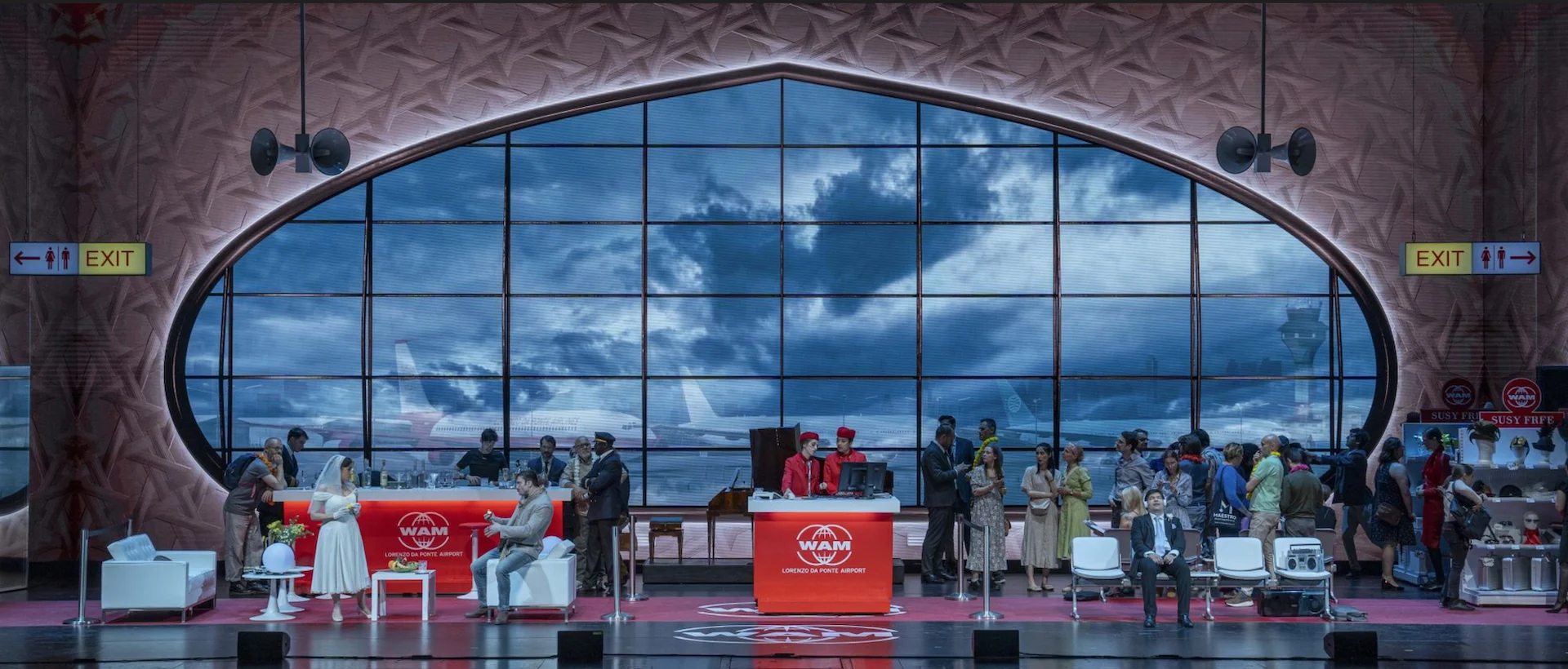 Une Folle Journée set: an airport terminal with a huge oval window, check-in desks and the full cast – Une Folle Journée Mozart Gala, Salzburg, Austria, 2024 – opera set design