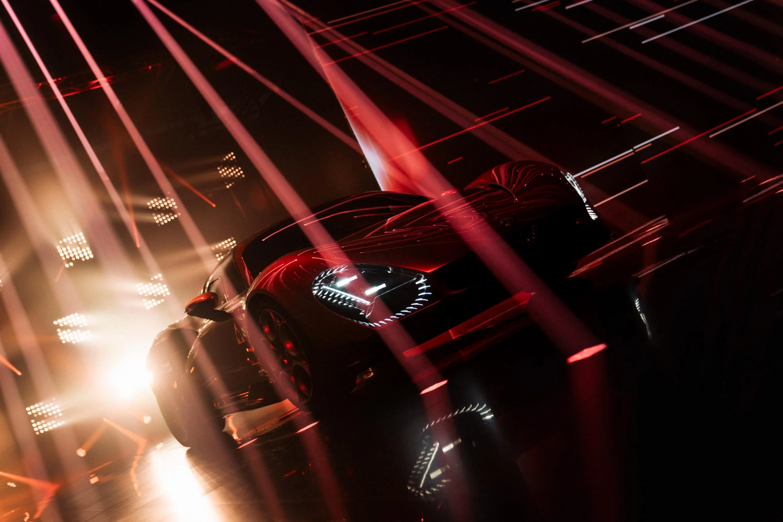 Low front view of the car under intersecting red light beams and bright white stage lights – Alfa Romeo 33 Stradale Unveiling, Arese, Italy, 2023 – event design