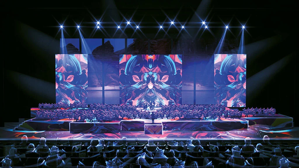 Render of a concert in the hall: orchestra on stage, colourful screens and spotlights over the audience – Maraya Concert Hall, AlUla, Saudi Arabia, 2019 – architecture