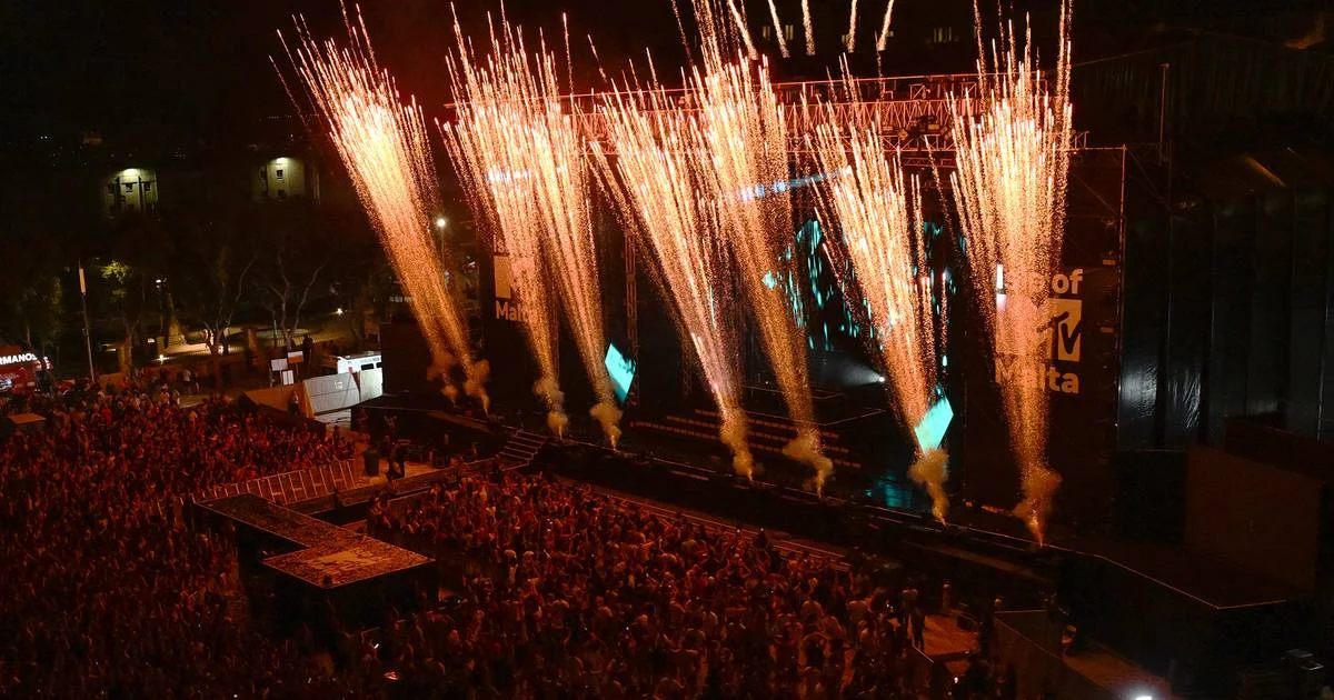 High view of the stage at night as a row of golden fireworks erupts above the crowd – Isle of MTV 2024, Floriana, Malta – concert stage design