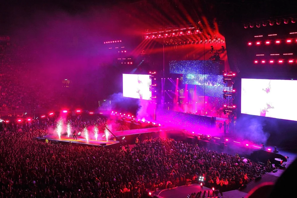 Stadium crowd in magenta light, sparklers on a runway and large side screens – Cesare Cremonini Stadi 2018, Italy – concert stage design